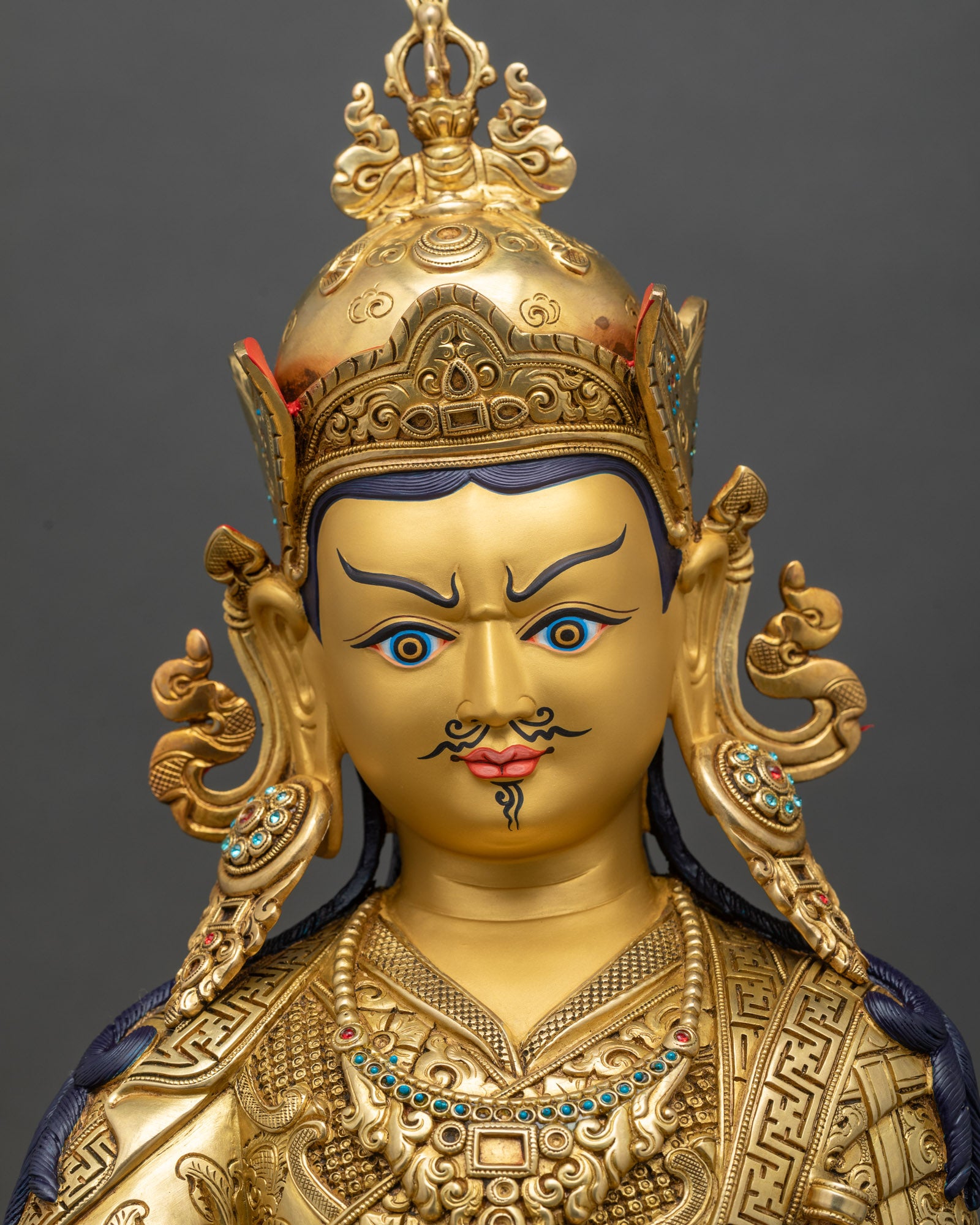Regular close-up of Guru Rinpoche statue showing intricate copper and gold details