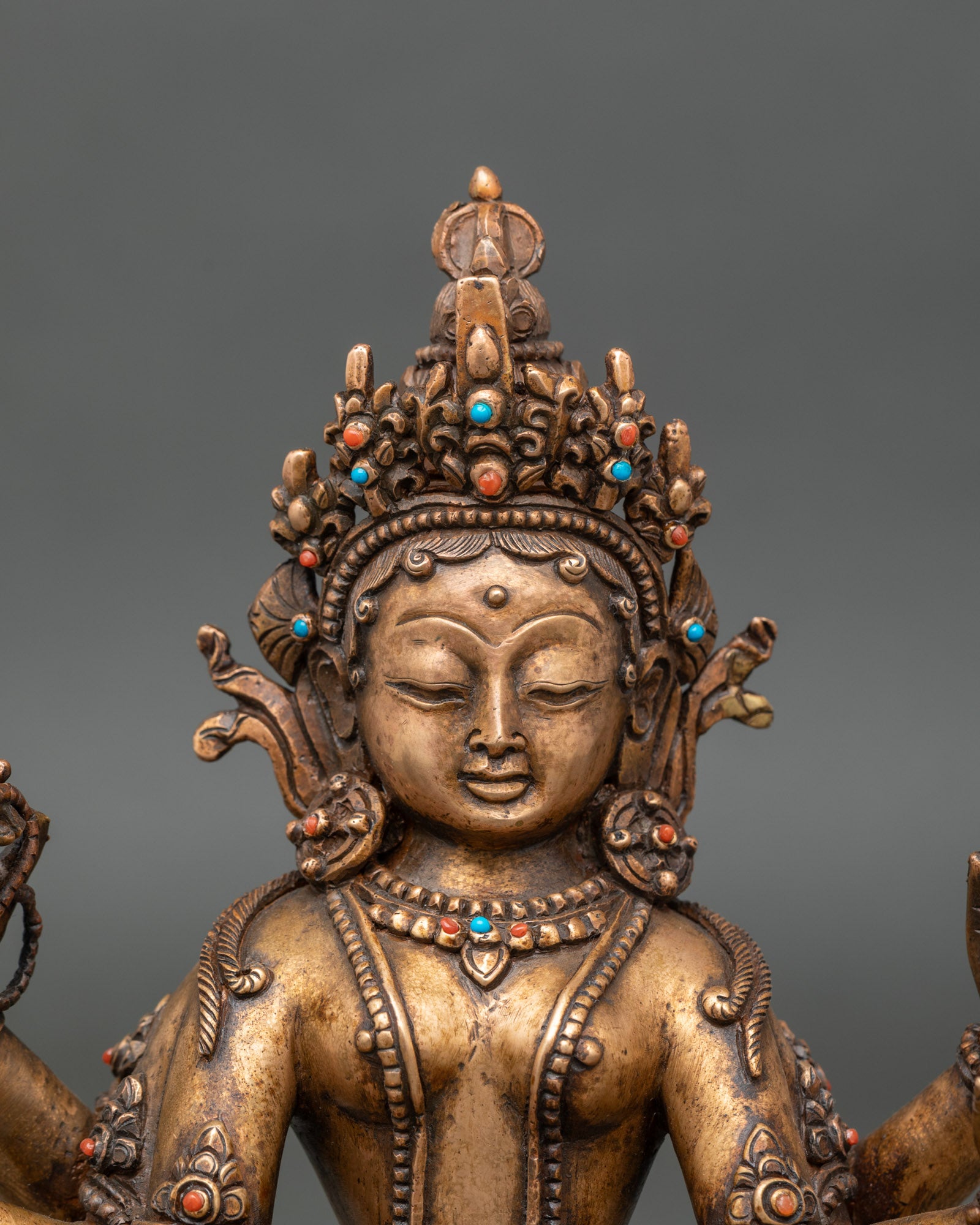 Regular close-up of Vasudhara statue showing copper, bronze details and stone inlays