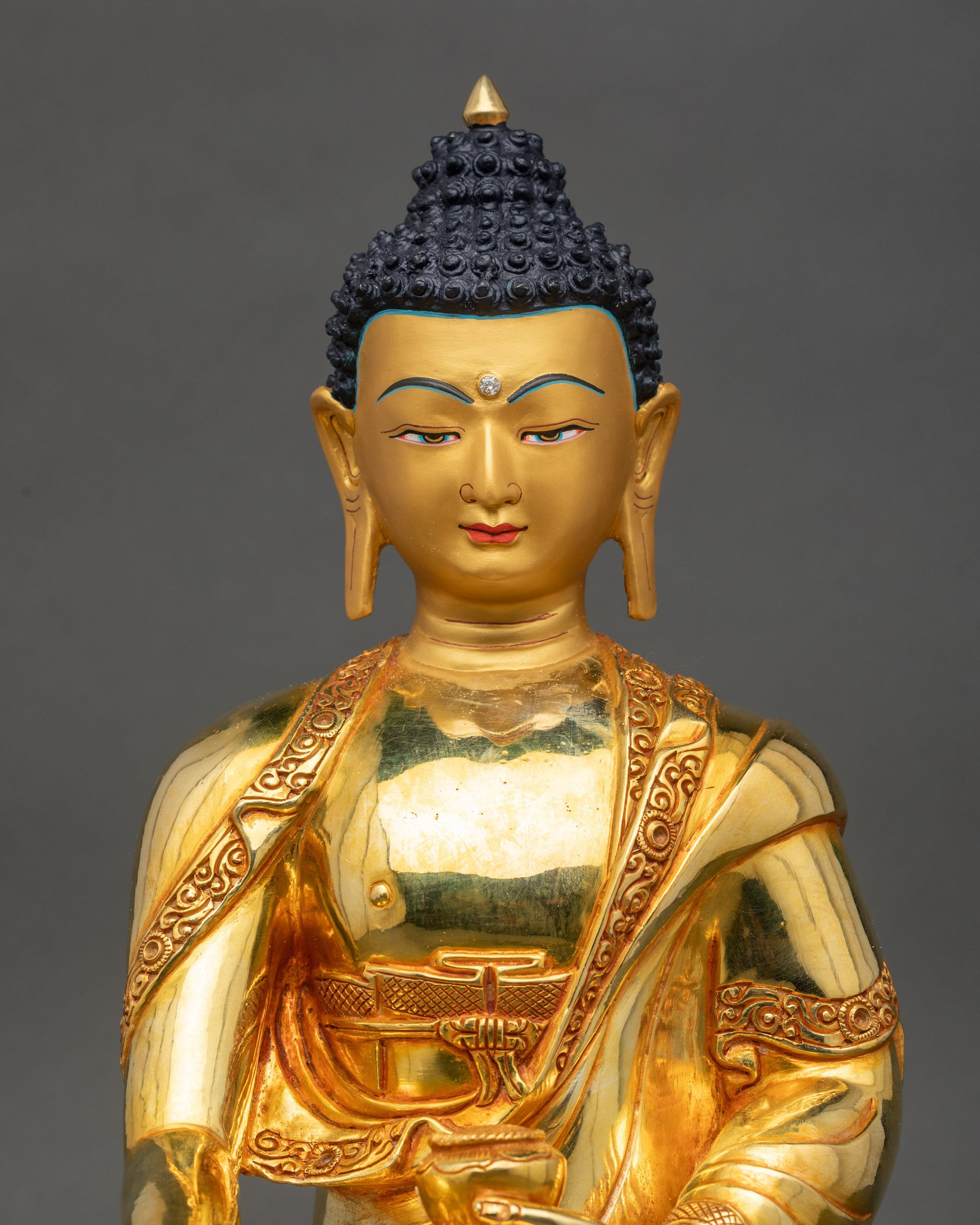 Regular close-up of Buddha Shakyamuni, polished copper and gold-painted face details