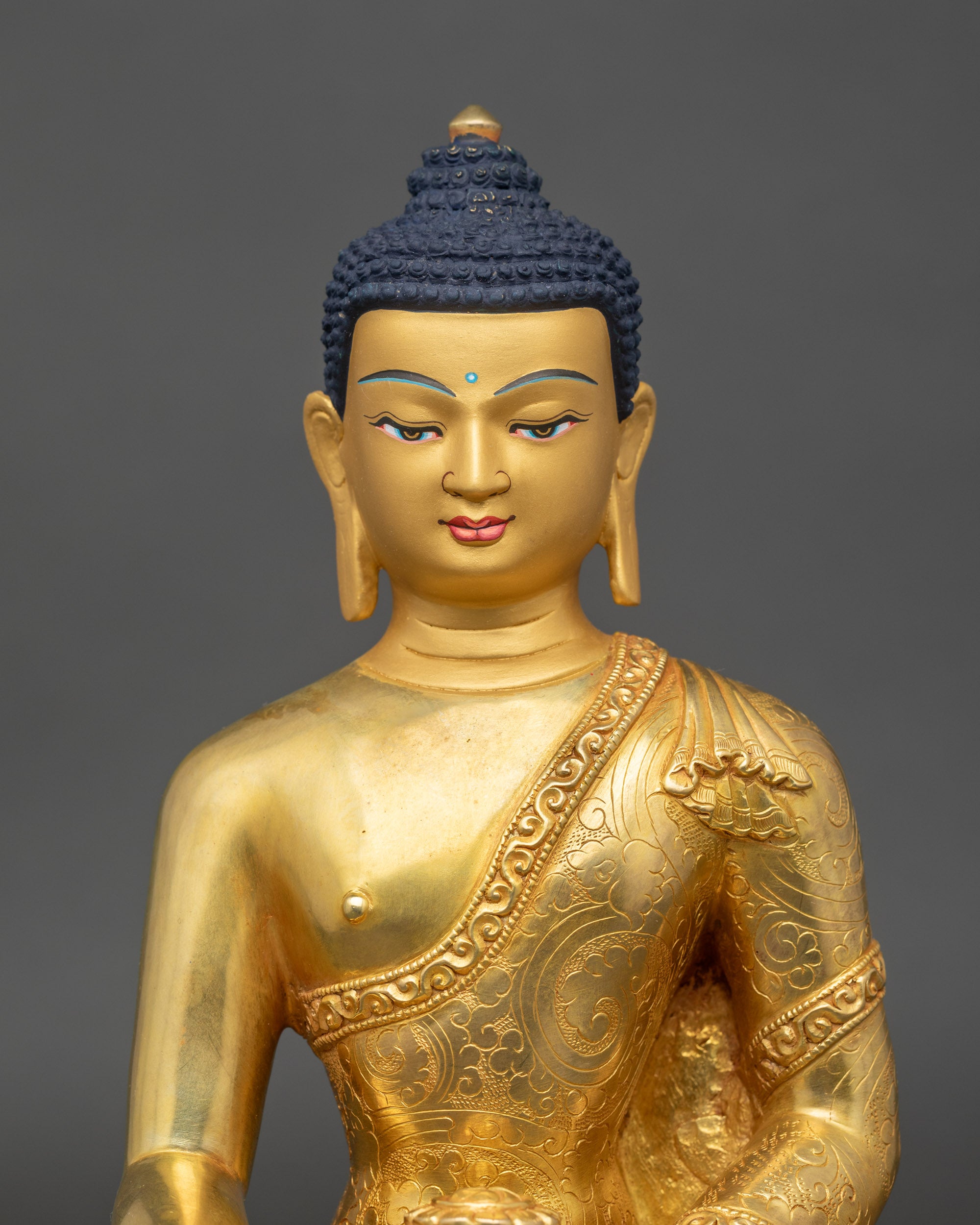 Regular close-up of Buddha Shakyamuni sculpture showing intricate robe patterns