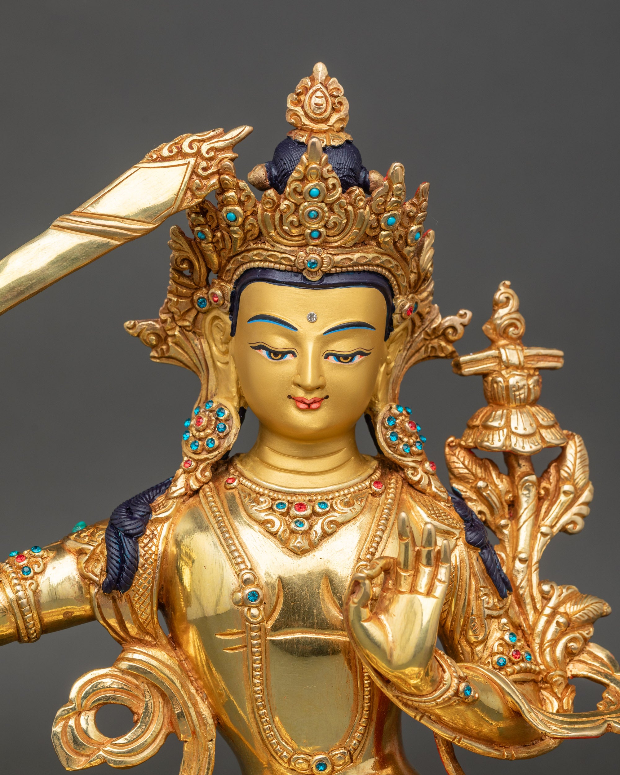 Regular close-up of Manjushri sculpture showing detailed lotus pedestal and copper craftsmanship