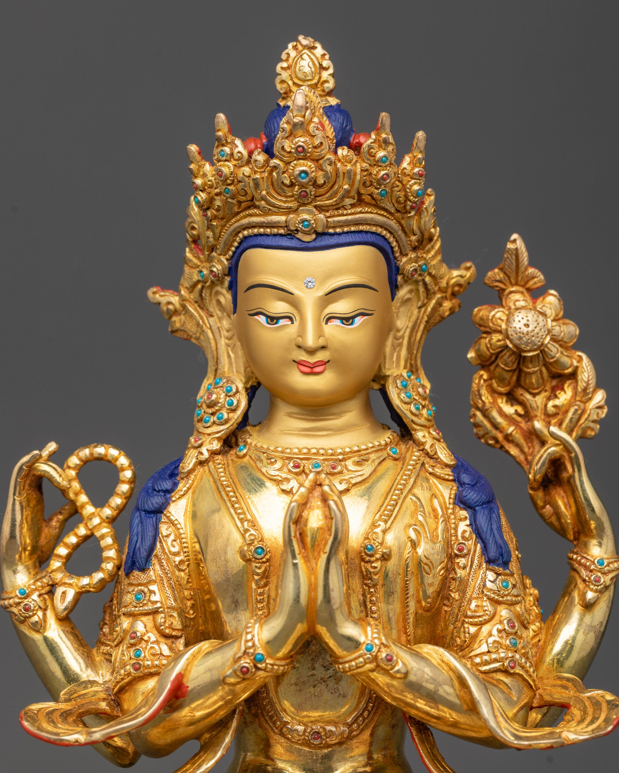 Regular close up Chenrezig Statue showing four arms holding sacred objects