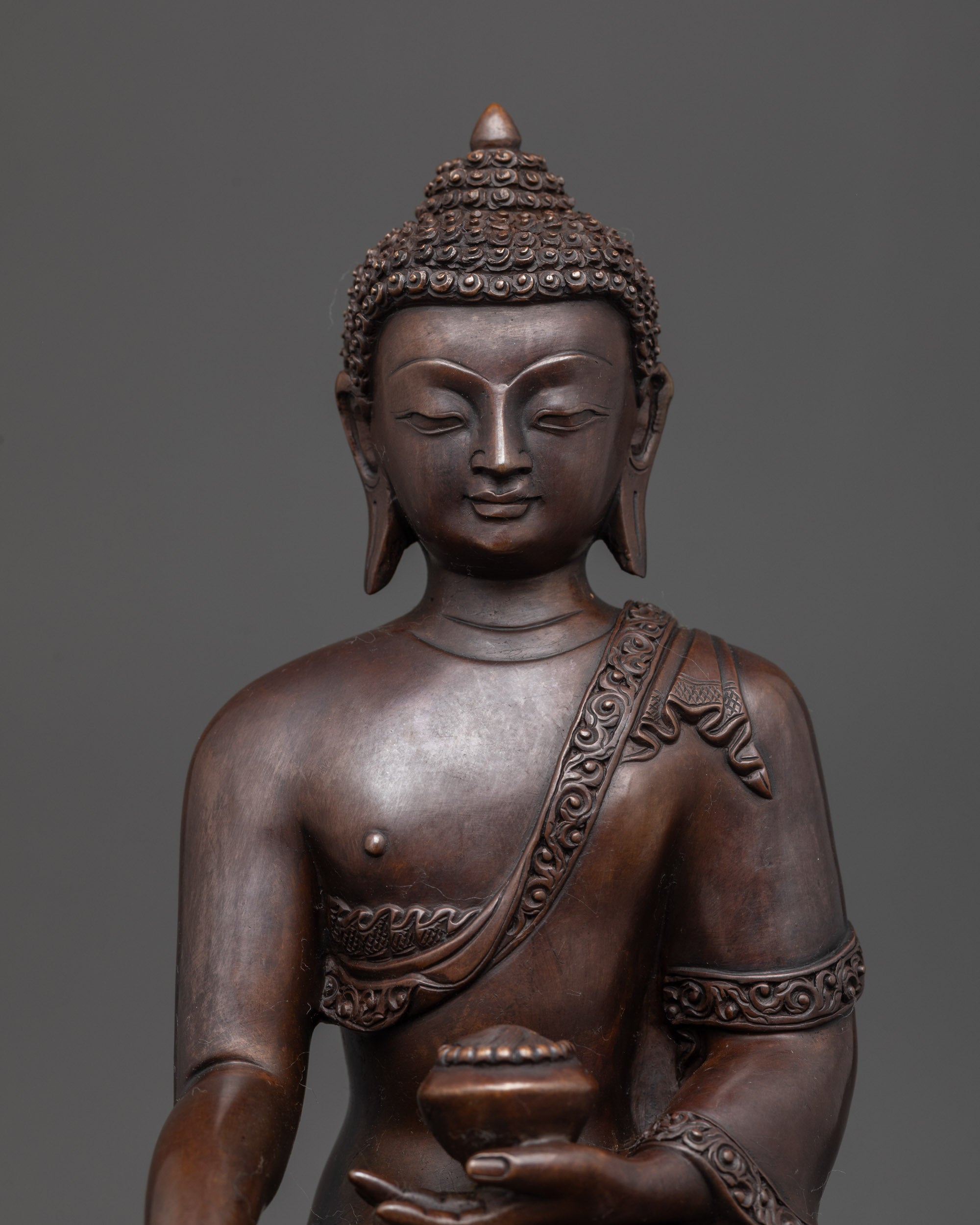 Regular close up: Oxidized Shakyamuni Buddha close up showing monk robe and meditation pose