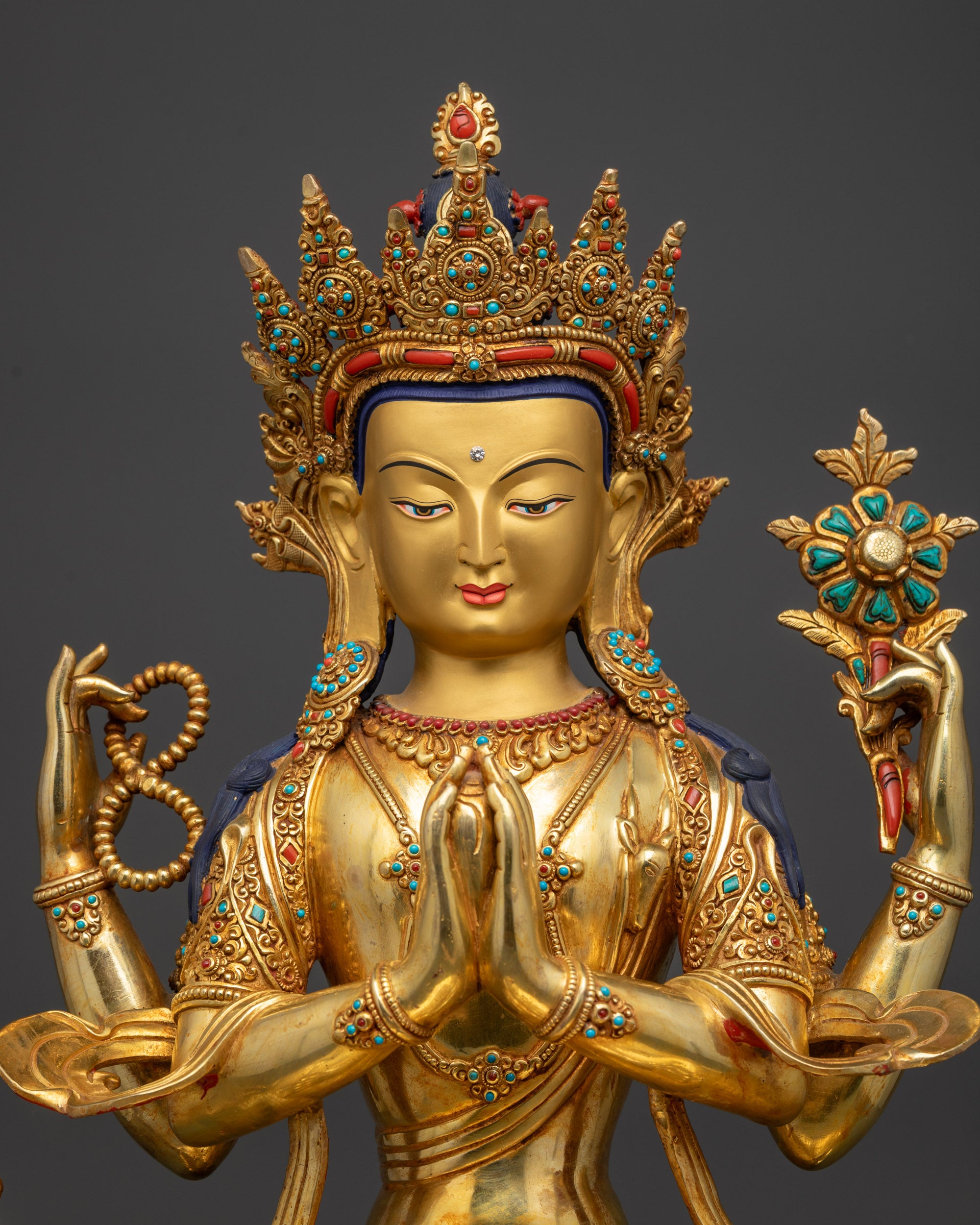 Regular close up handcrafted Chenrezig Buddhist statue showing four arms sacred objects