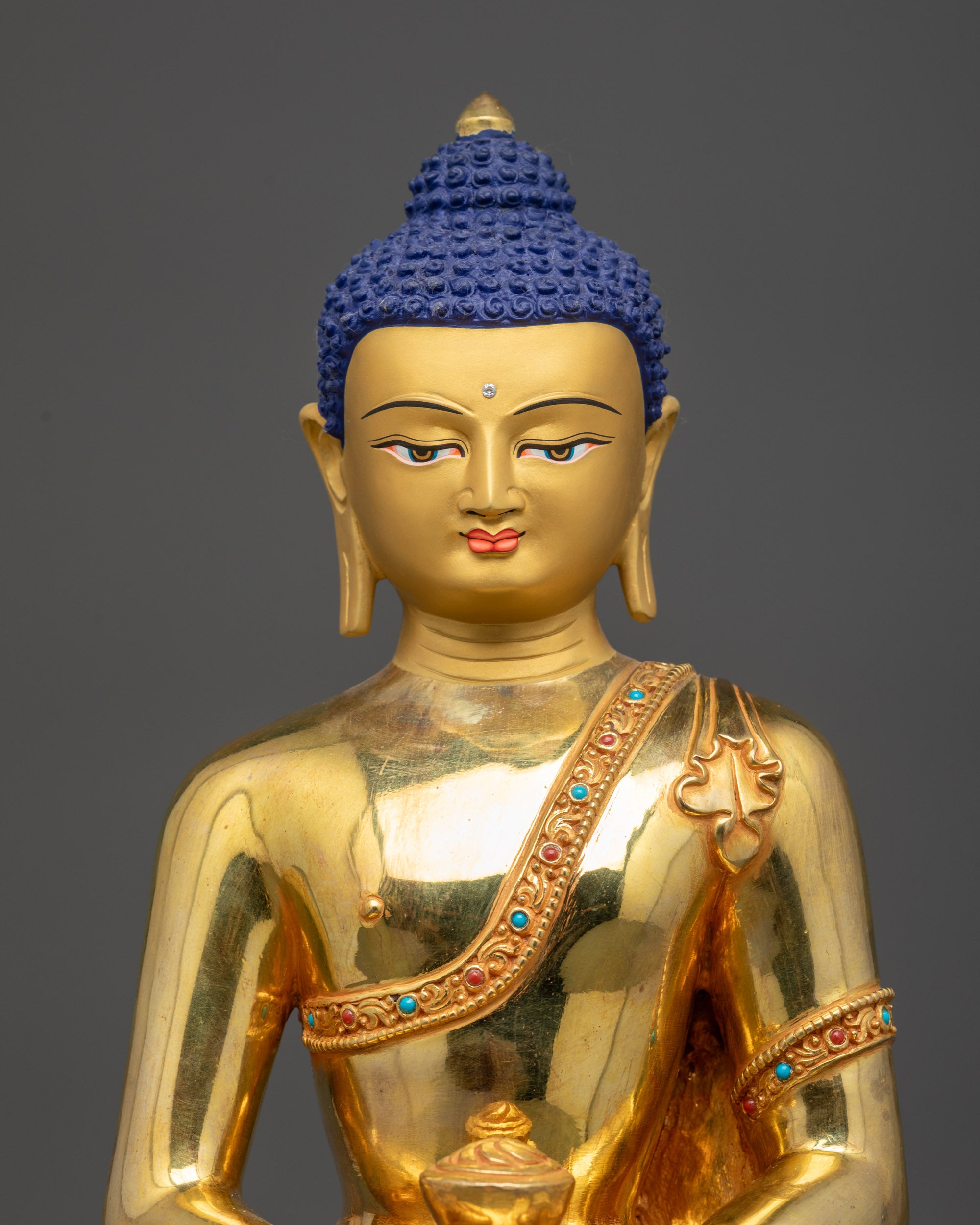 Regular close up of Amitabha Buddha sculpture showing intricate carved monk's robe