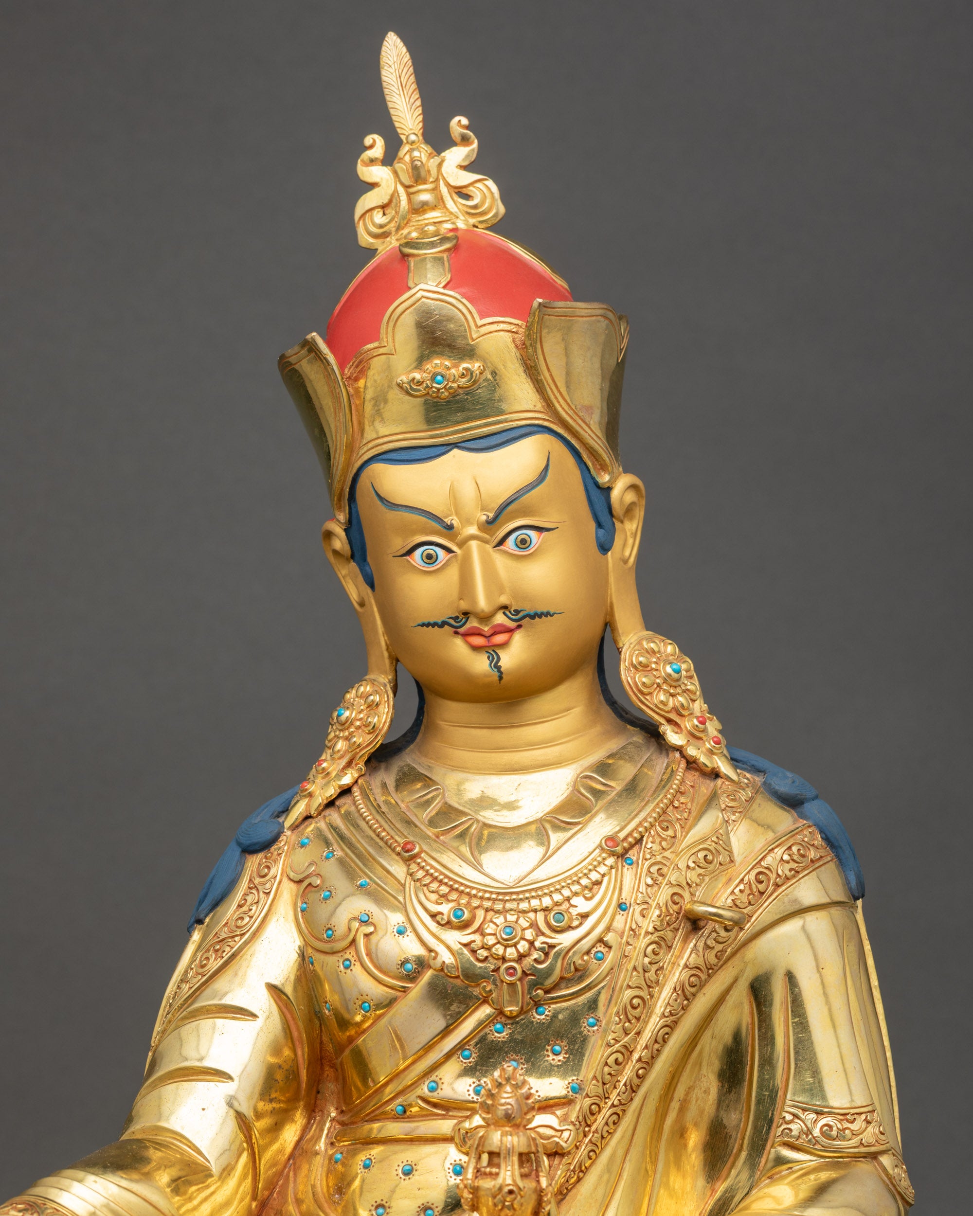 Regular close up of Guru Rinpoche Statue showing layered robes and ornate Khatvanga trident