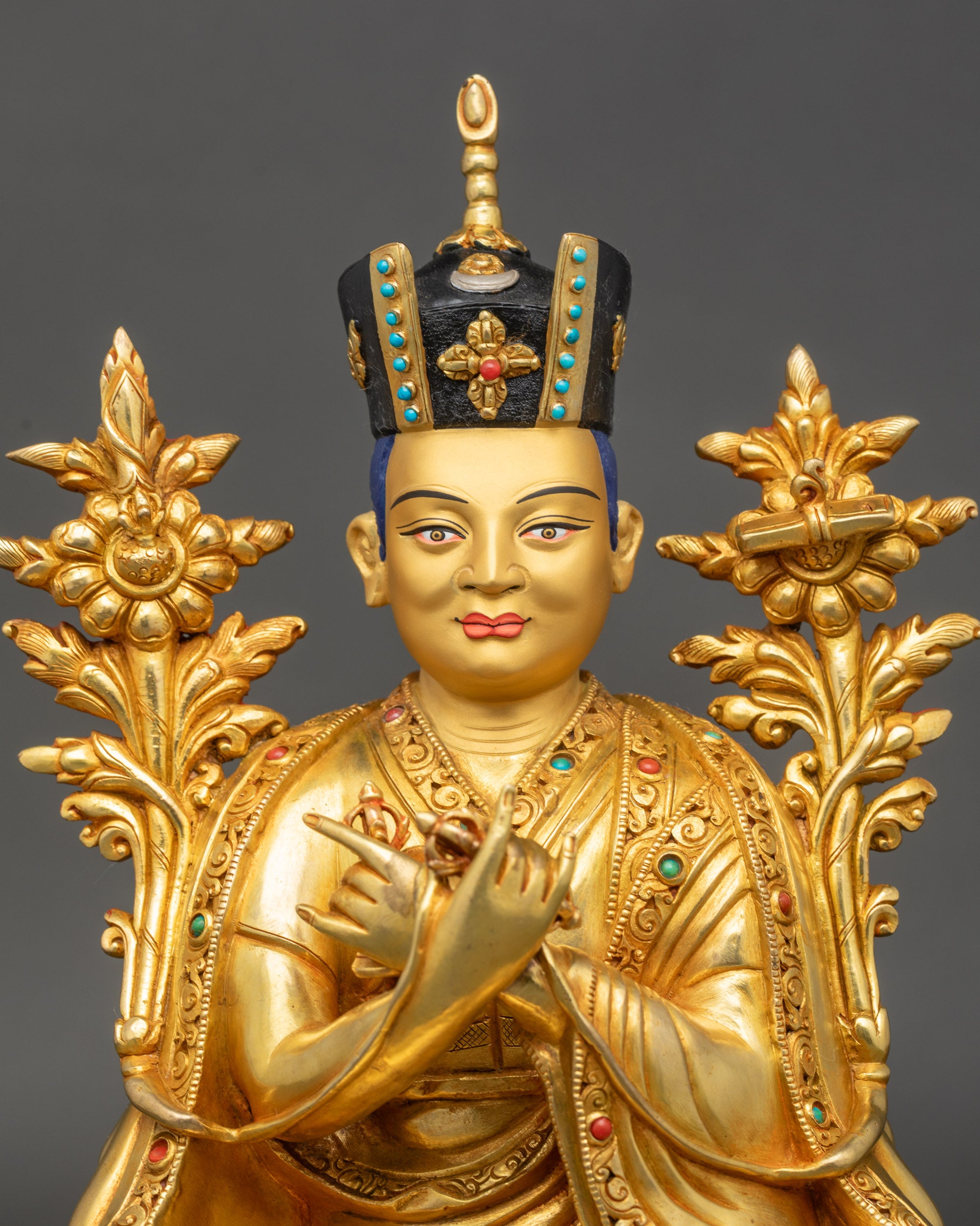Regular close up of Karmapa statue showing gilded face, crown, and monk robe details