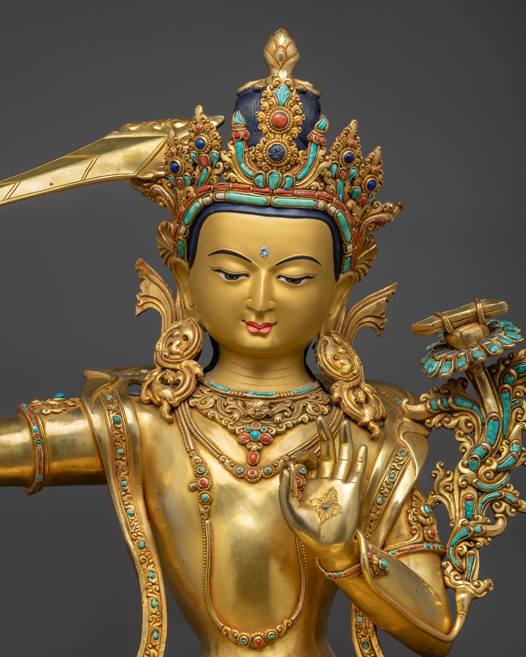 Regular close up of Manjushri statue highlighting Abhaya mudra and ornaments