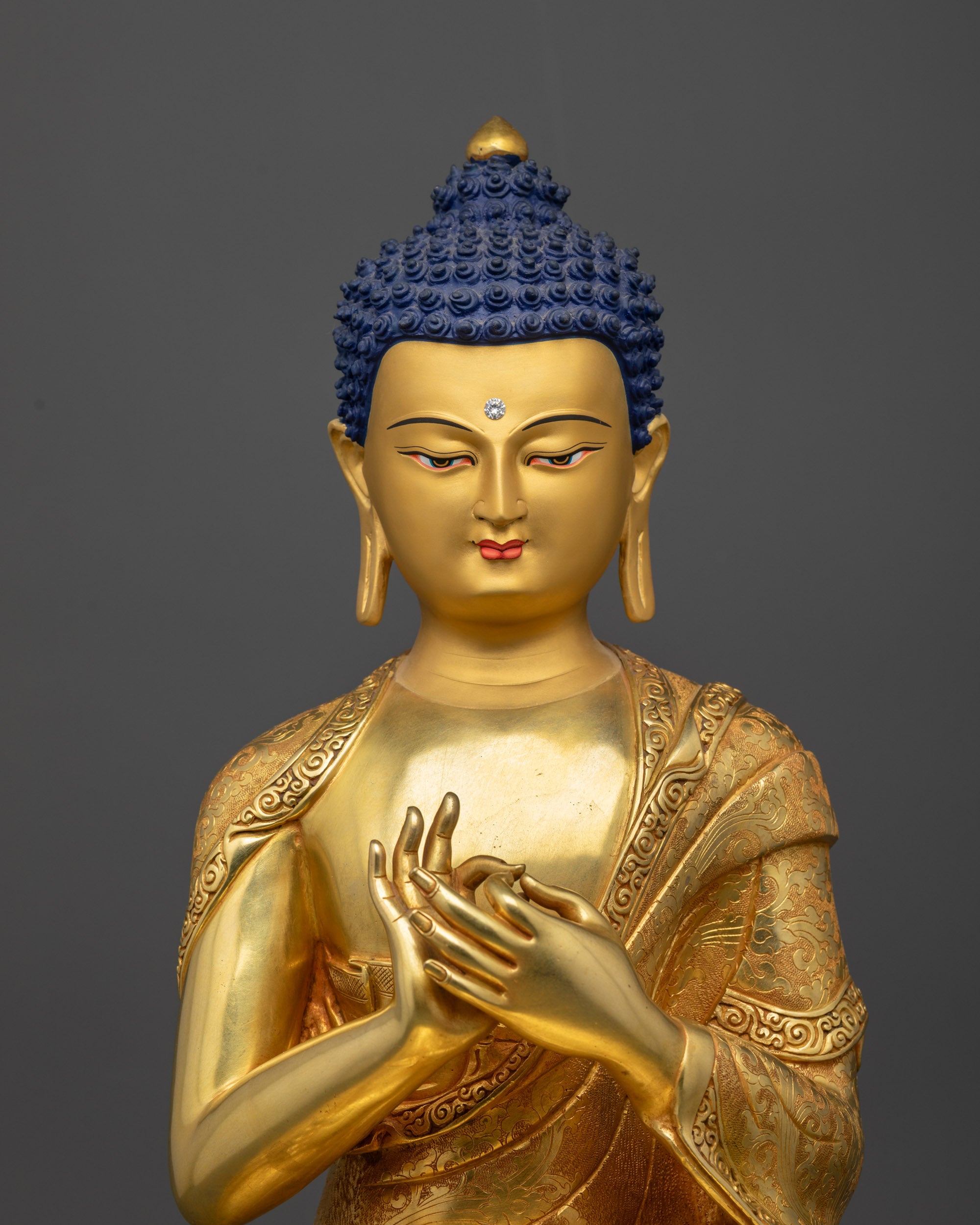 Regular close up of Vairocana Buddha statue showing gold fire-gilded base and robes