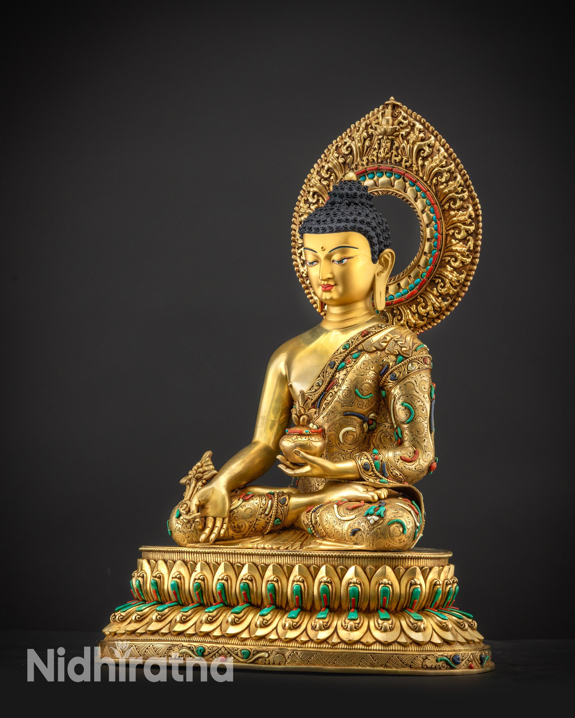 Regular side left view of Medicine Buddha with textured golden body and intricate filigree work
