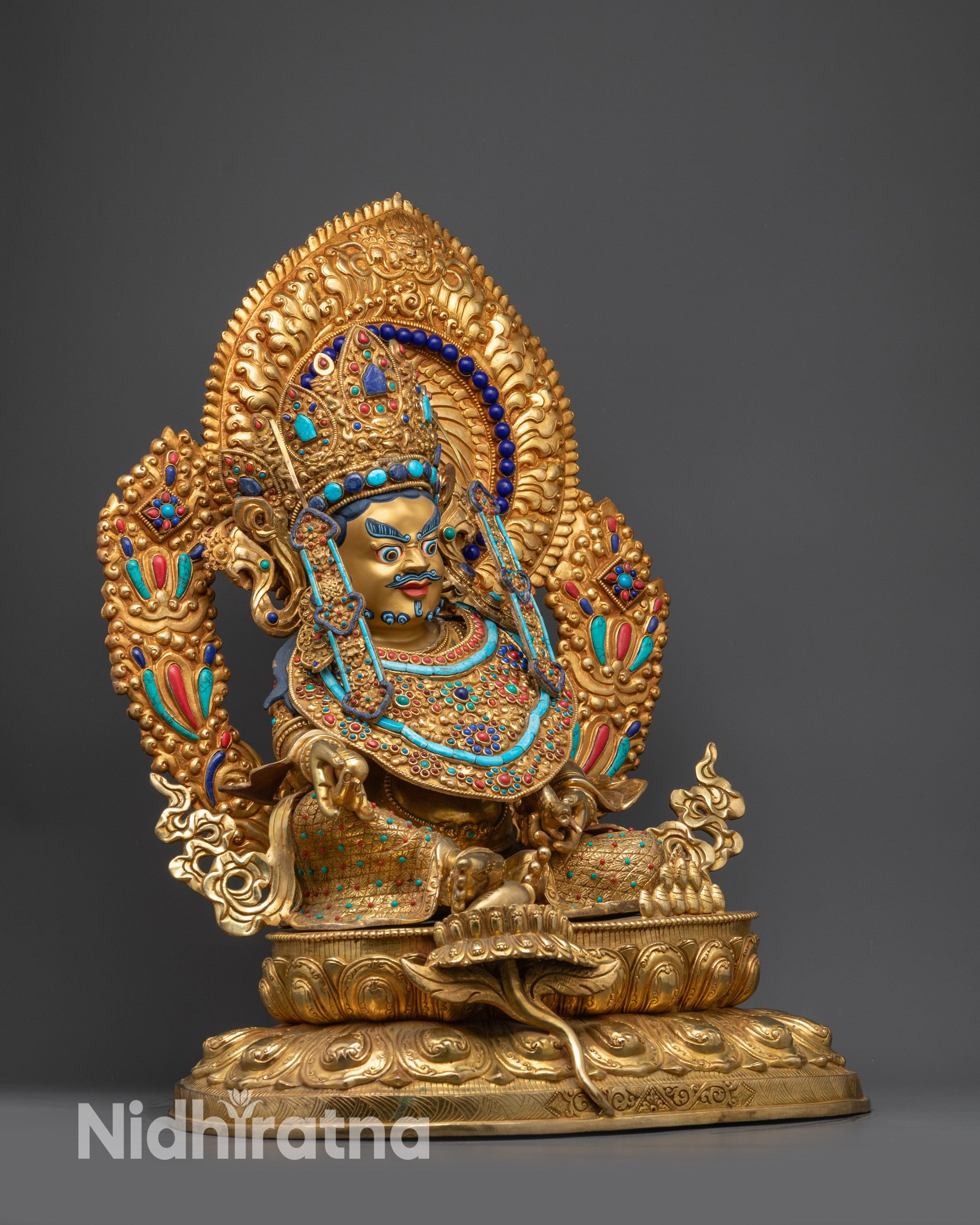 Regular side view of Dzambhala statue showing robes, lotus pedestal, and crown details