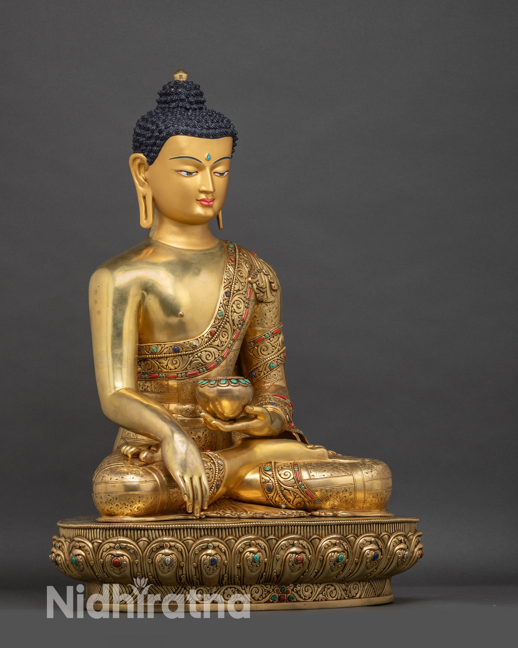 Right-side view of life-size Shakyamuni Buddha, showing cross-legged pose and decorative accents