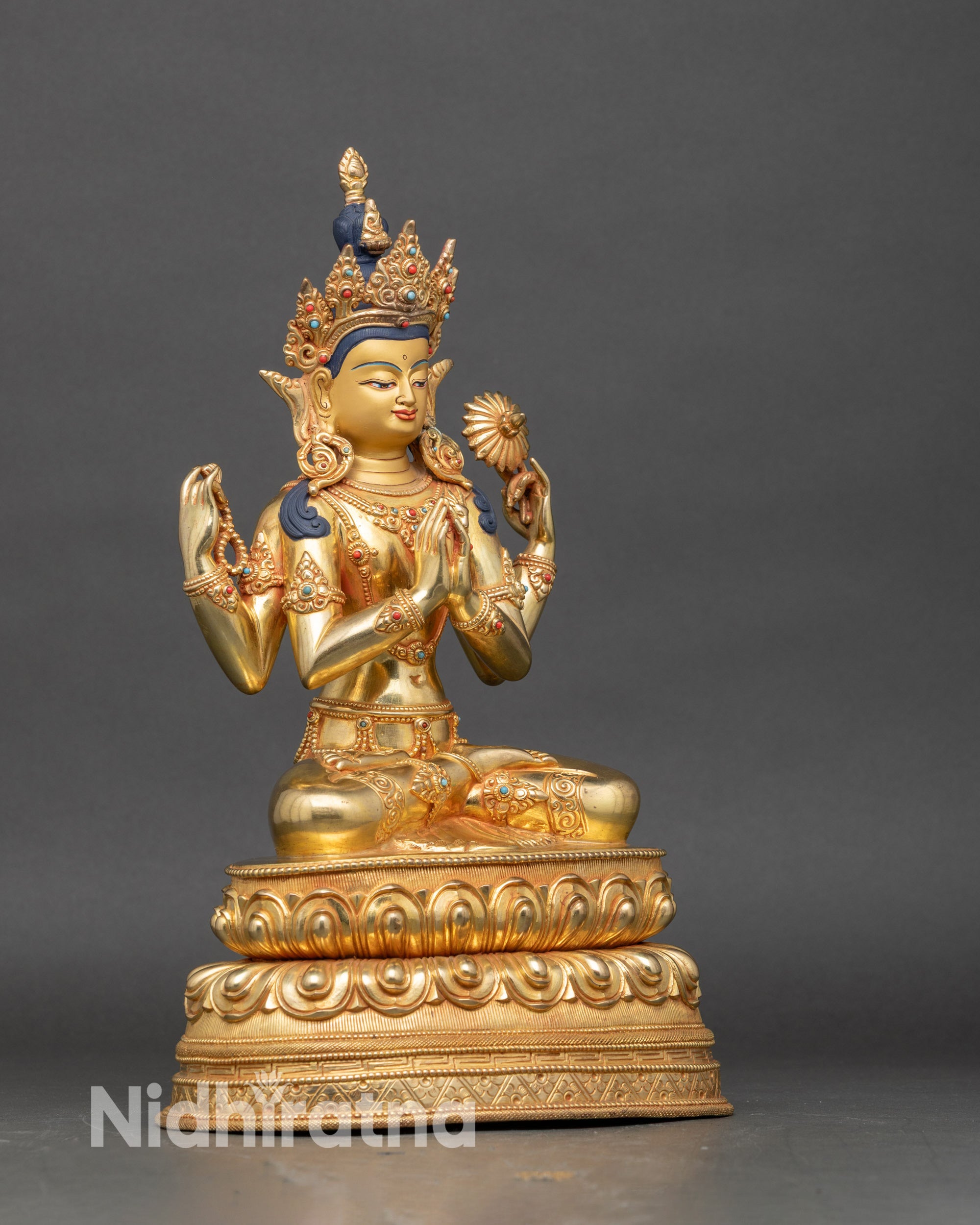 Right side of Chenrezig statue highlighting crystal rosary and flowing robes