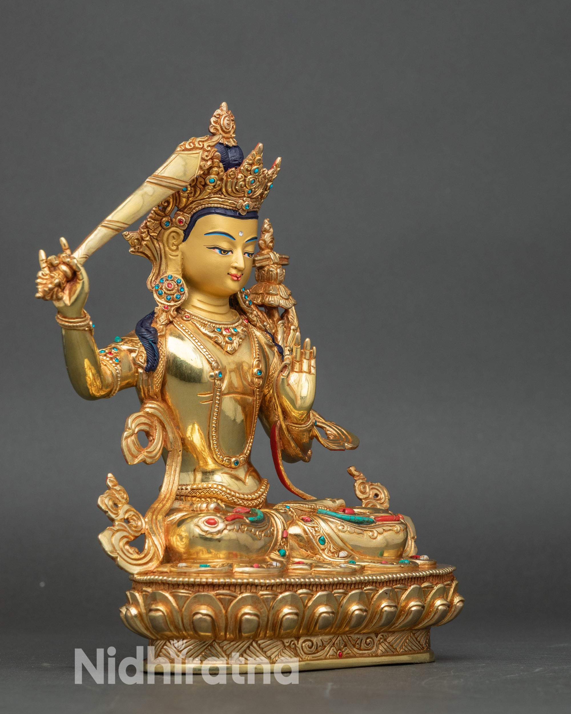 Right side view of Manjushri Bodhisattva figurine, copper sculpture with gold accents for altar