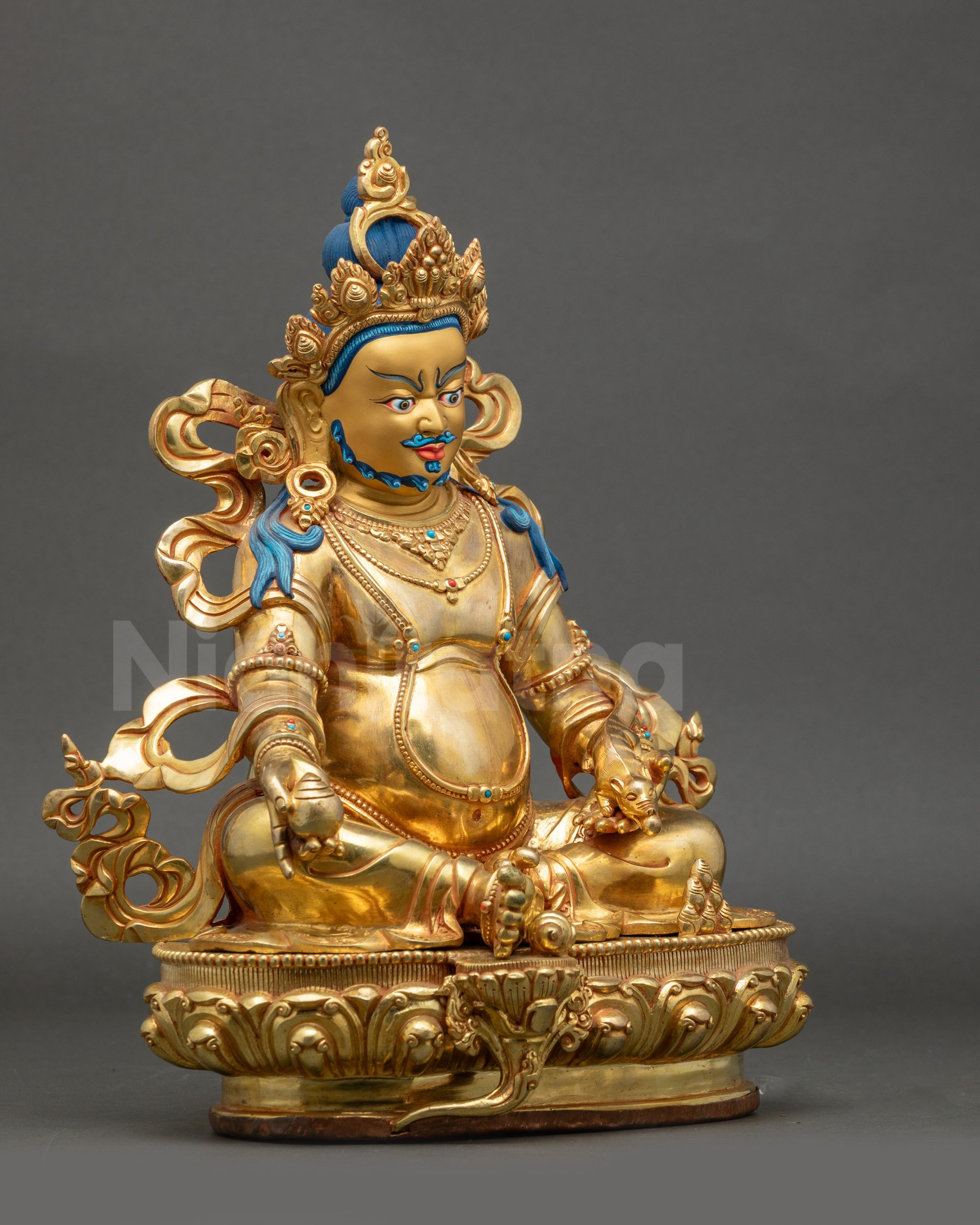 Right view side Dzambhala statue on lotus seat with radiant gold fire-gilded base