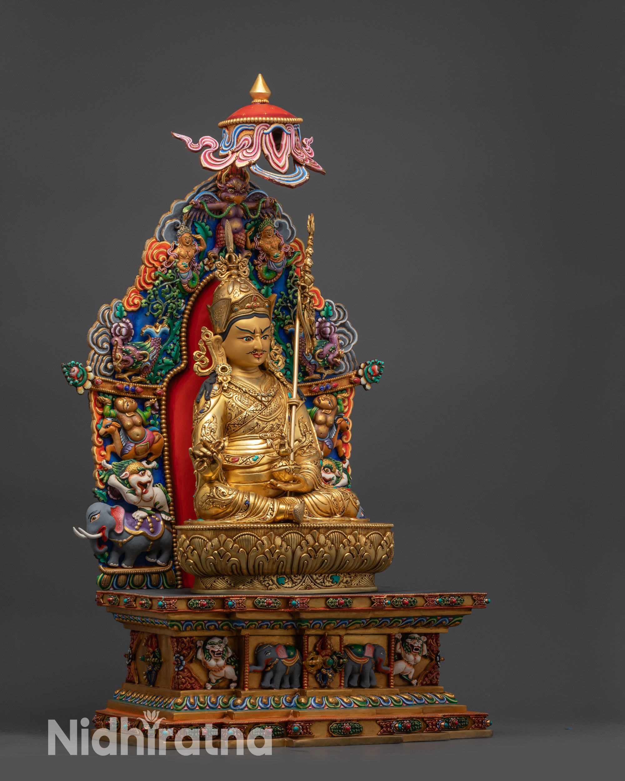 Right view side of Guru Rinpoche statue on Tibetan-style throne with parasol