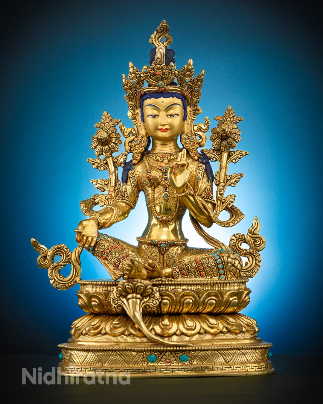 A traditionally hand-carved Goddess Green Tara statue seated in a meditative lotus posture, adorned with semi-precious gemstones and 24k gold plating, symbolizing compassion and enlightenment.