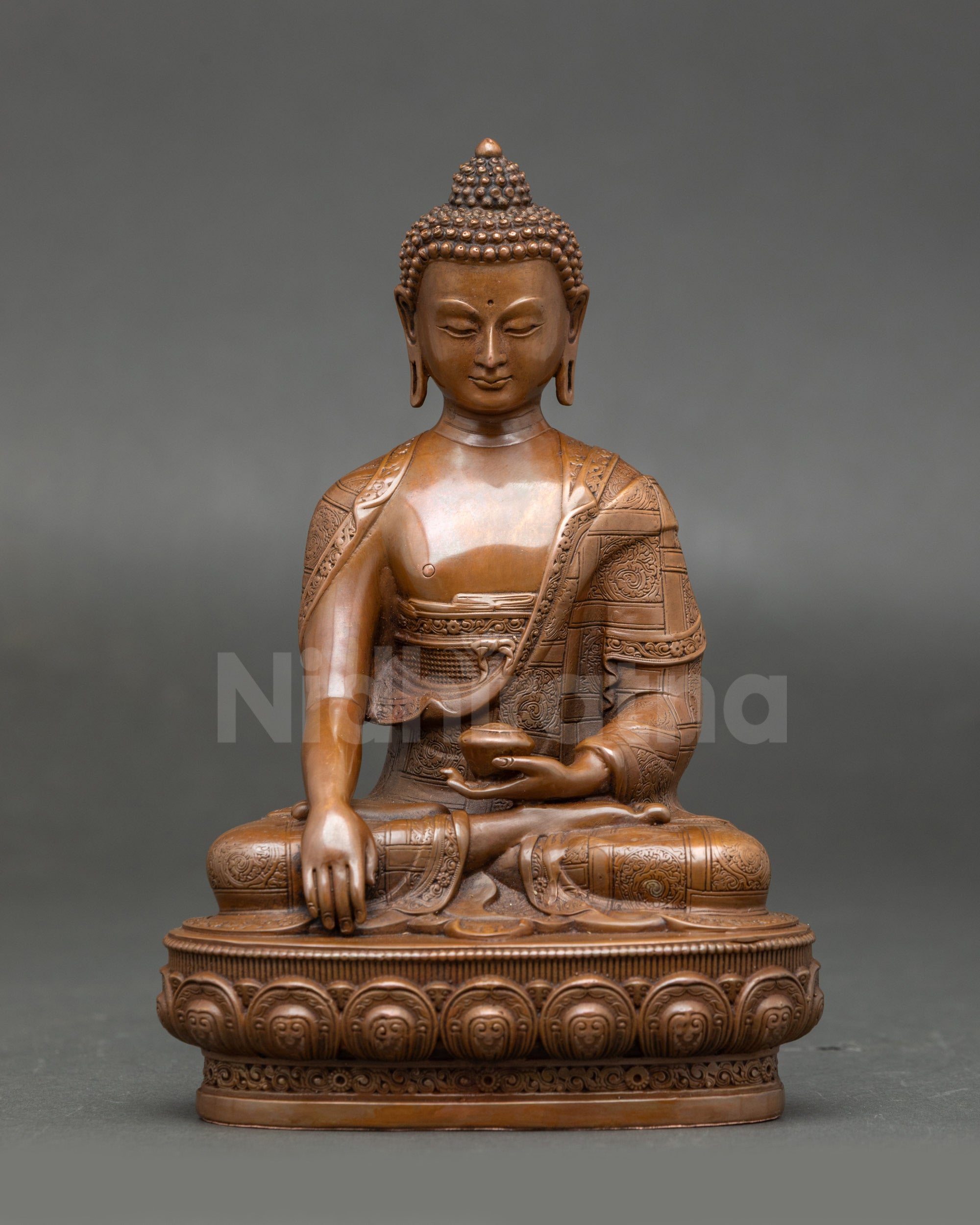 Sacred Shakyamuni Buddha Statue seated on a lotus throne, holding an alms bowl, a chemically oxidized Nepalese Buddhist sculpture