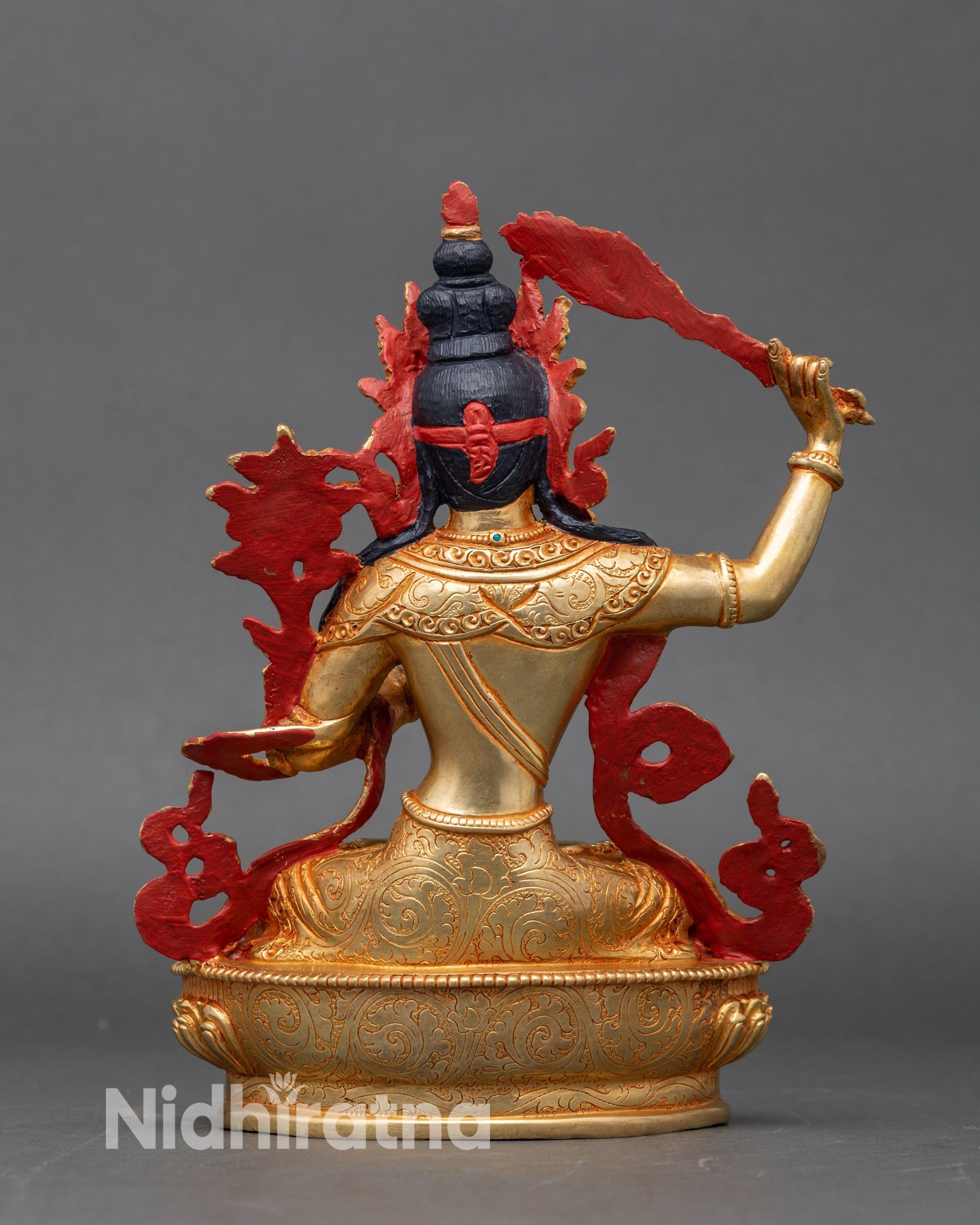 Serene gold-painted face of Manjushri, detailed meditation sculpture