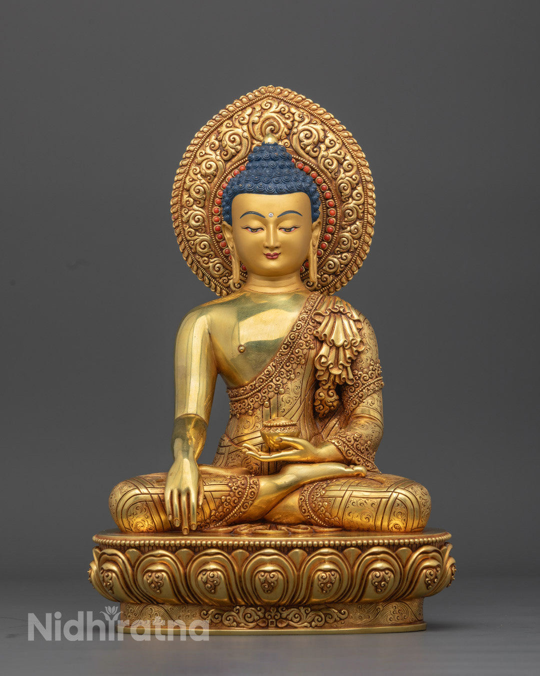 Hand-carved in Nepal, featuring a gold fire gilded copper body with vibrant acrylic colors and a radiant halo, symbolizing enlightenment and inner peace.