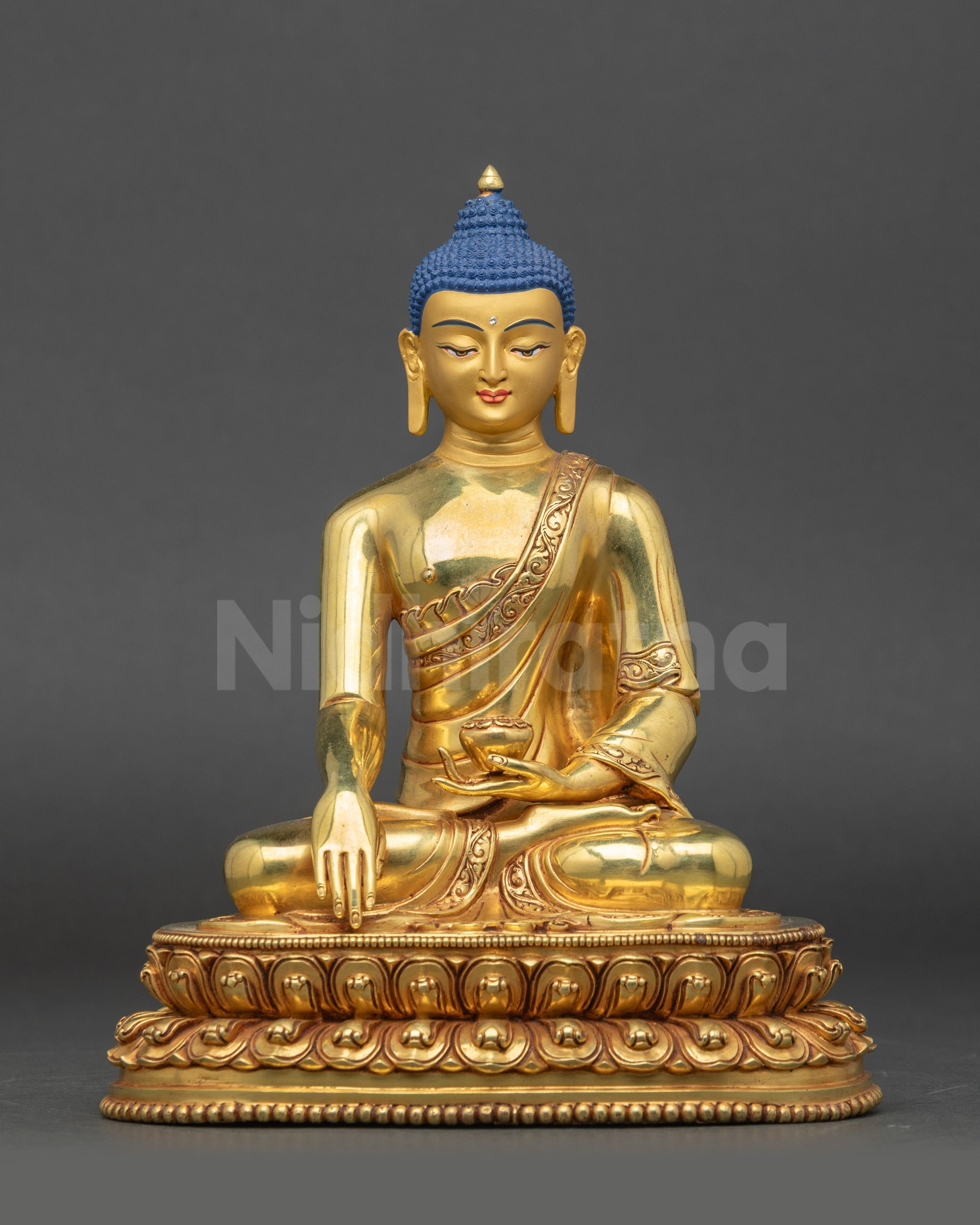 Front view of gold-gilded Shakyamuni Buddha statue seated on lotus pedestal