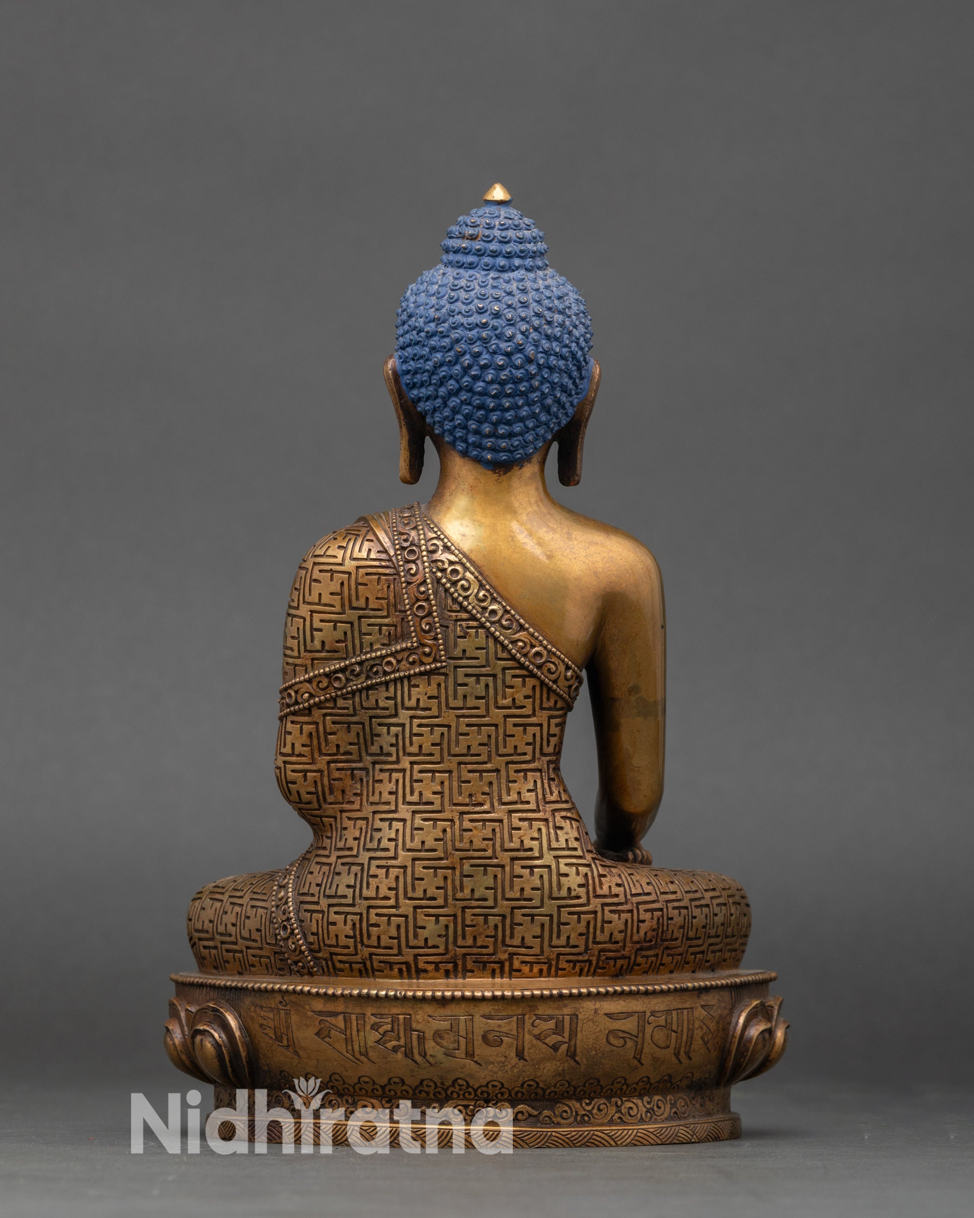 Shakyamuni Buddha statue back view showing double-lotus pedestal and engraved mantra