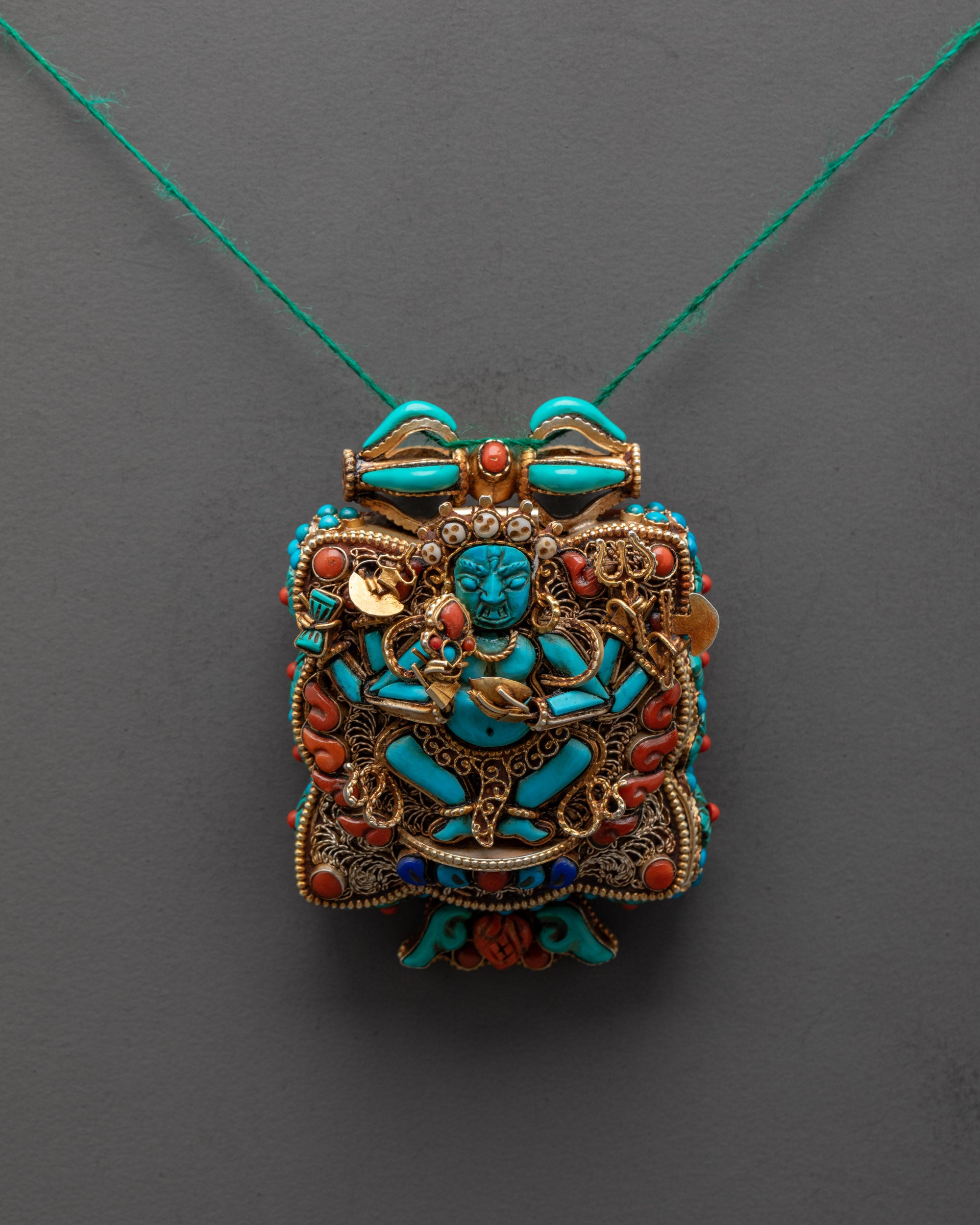 Shop Mahakala Praying Box Locket front view gold-plated turquoise figure with filigree design
