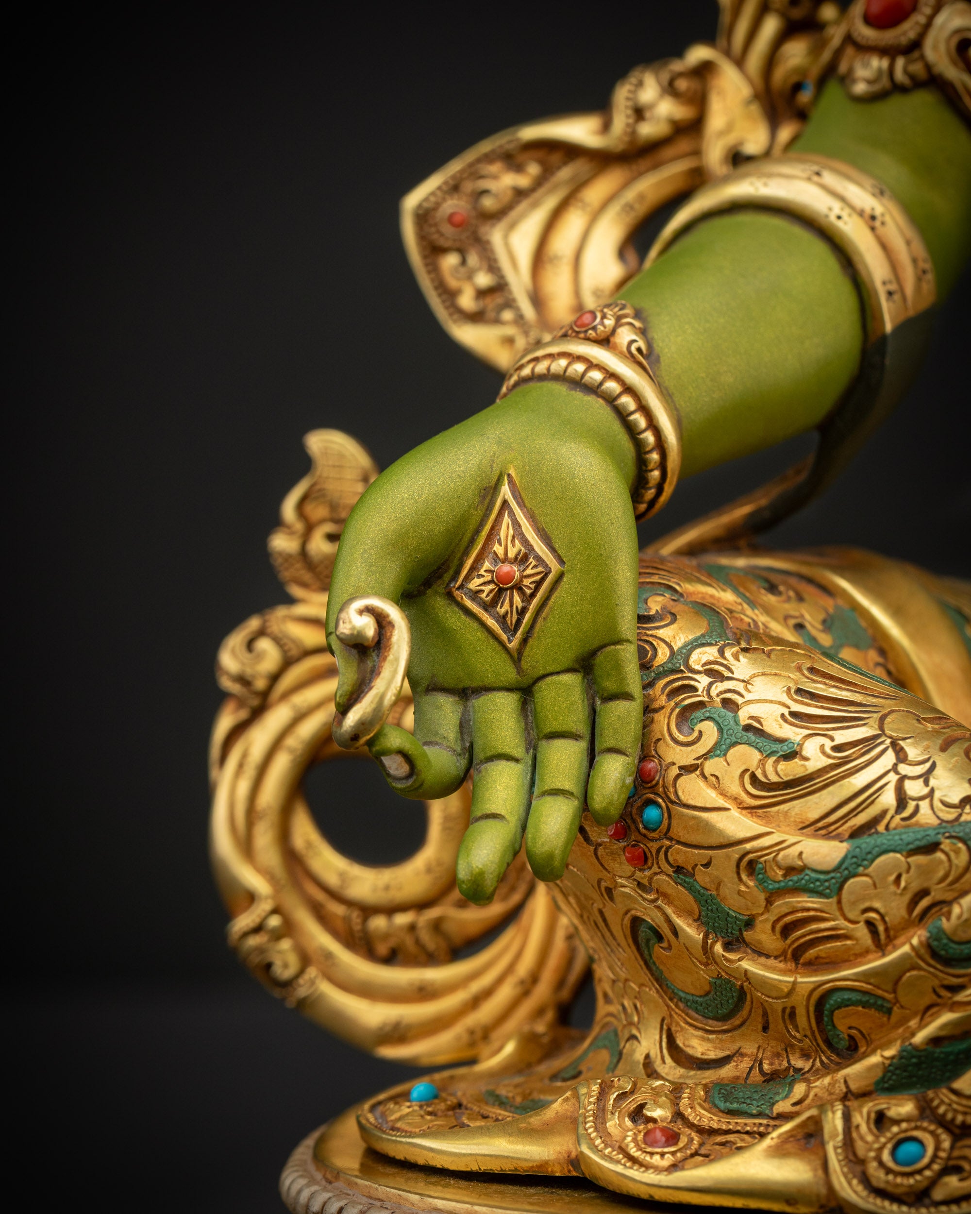 Detailed close up of Shyama Tara statue right hand forming varada mudra symbolizing generosity compassion