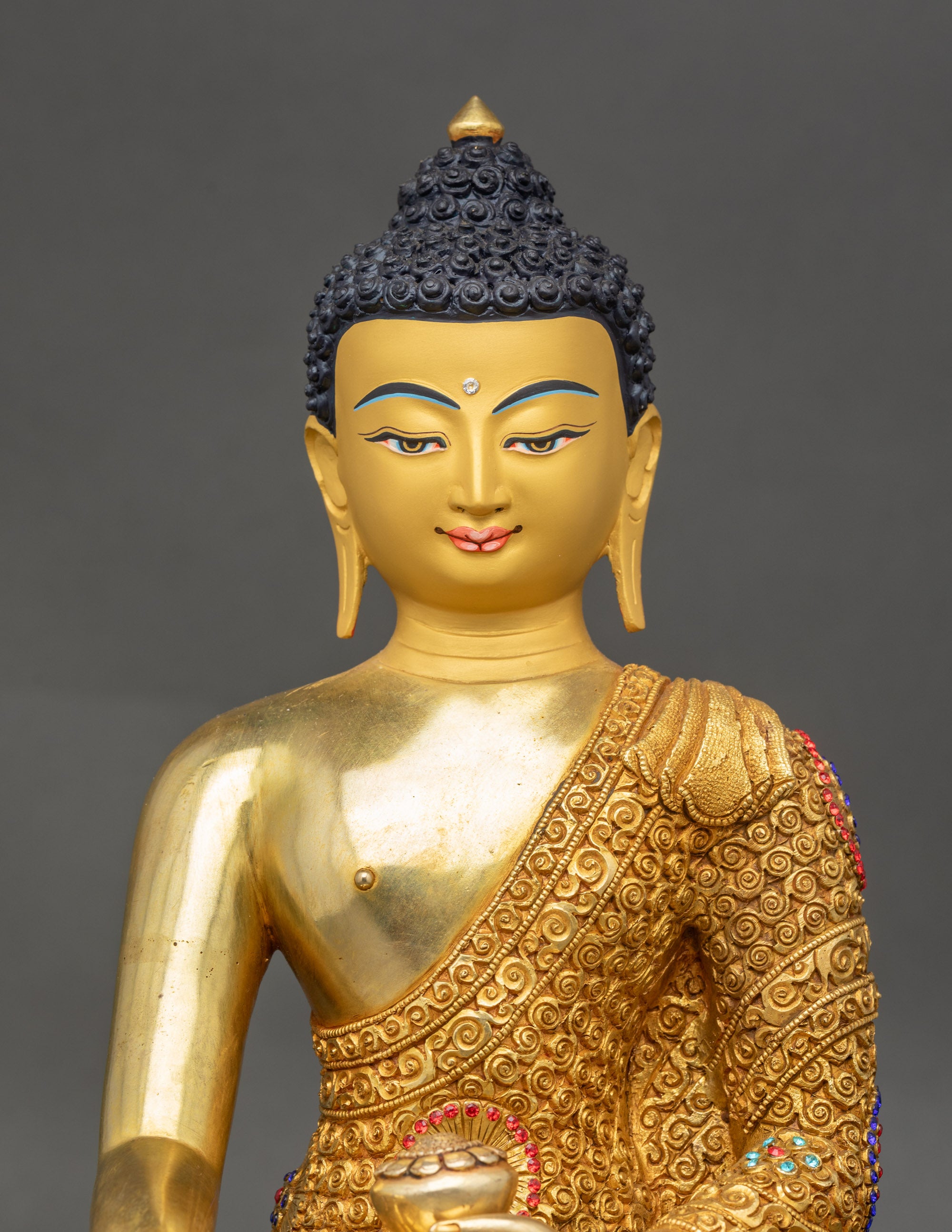 Siddhartha Gautama Buddha close up copper sculpture gold-gilded details