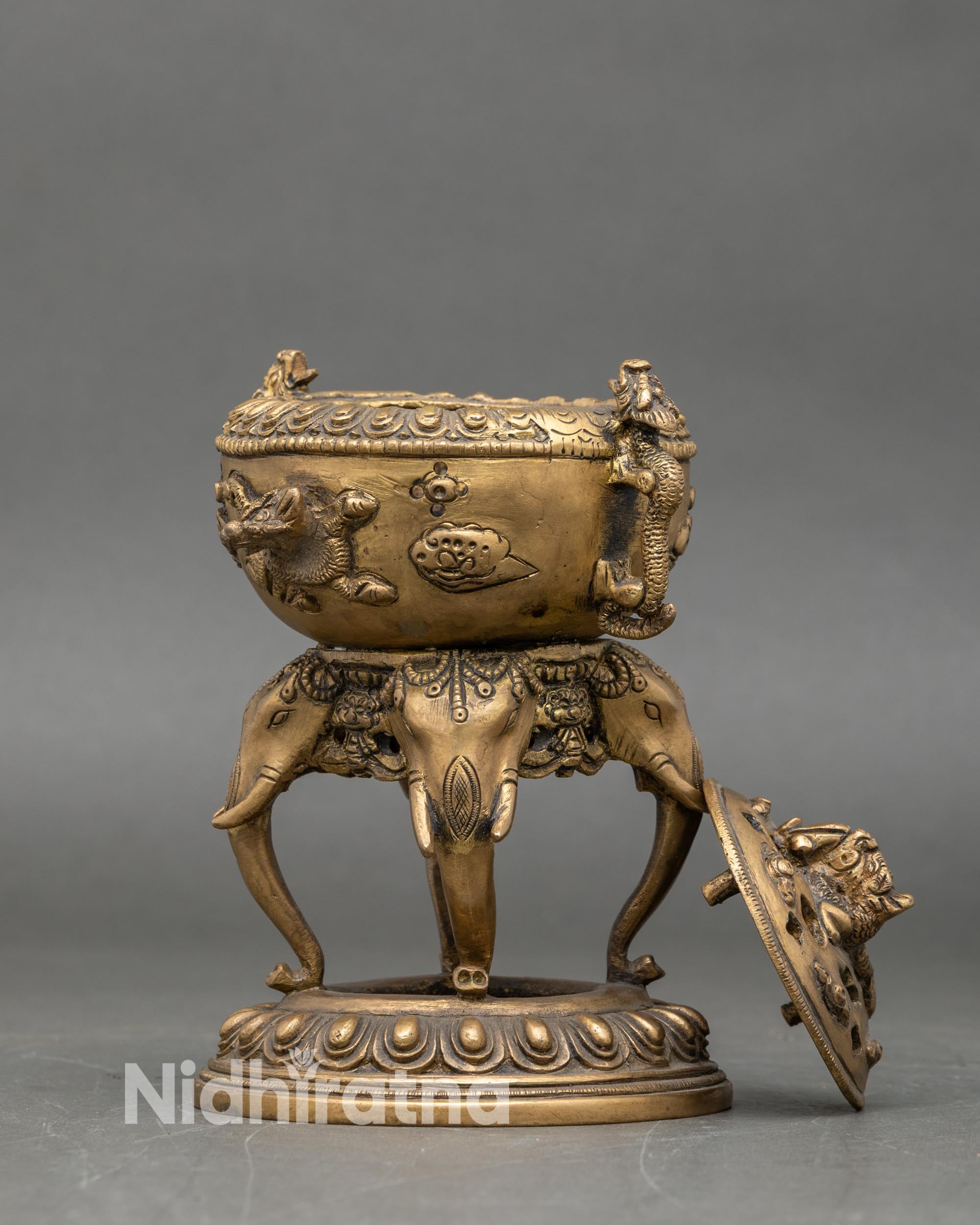 Side view of traditional Nepali brass censer with elephant stand and lotus petal base