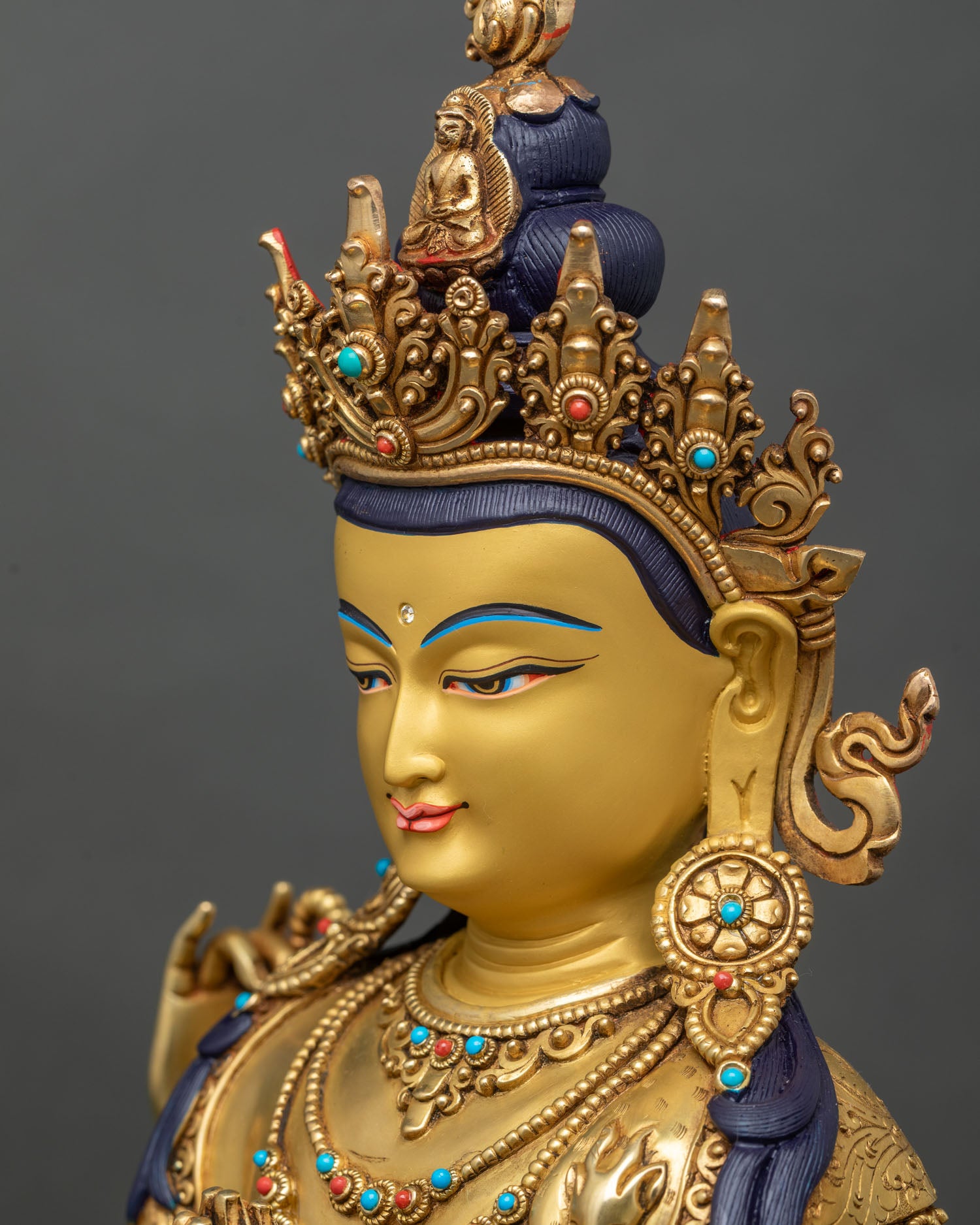 Side close-up of Chenrezig statue highlighting crystal mala, lotus flower, and hand posture