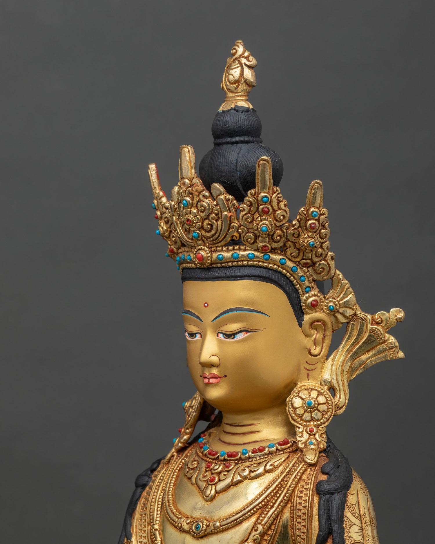 Side detail of crowned Shakyamuni Buddha statue with crown, jewelry, and lotus pedestal