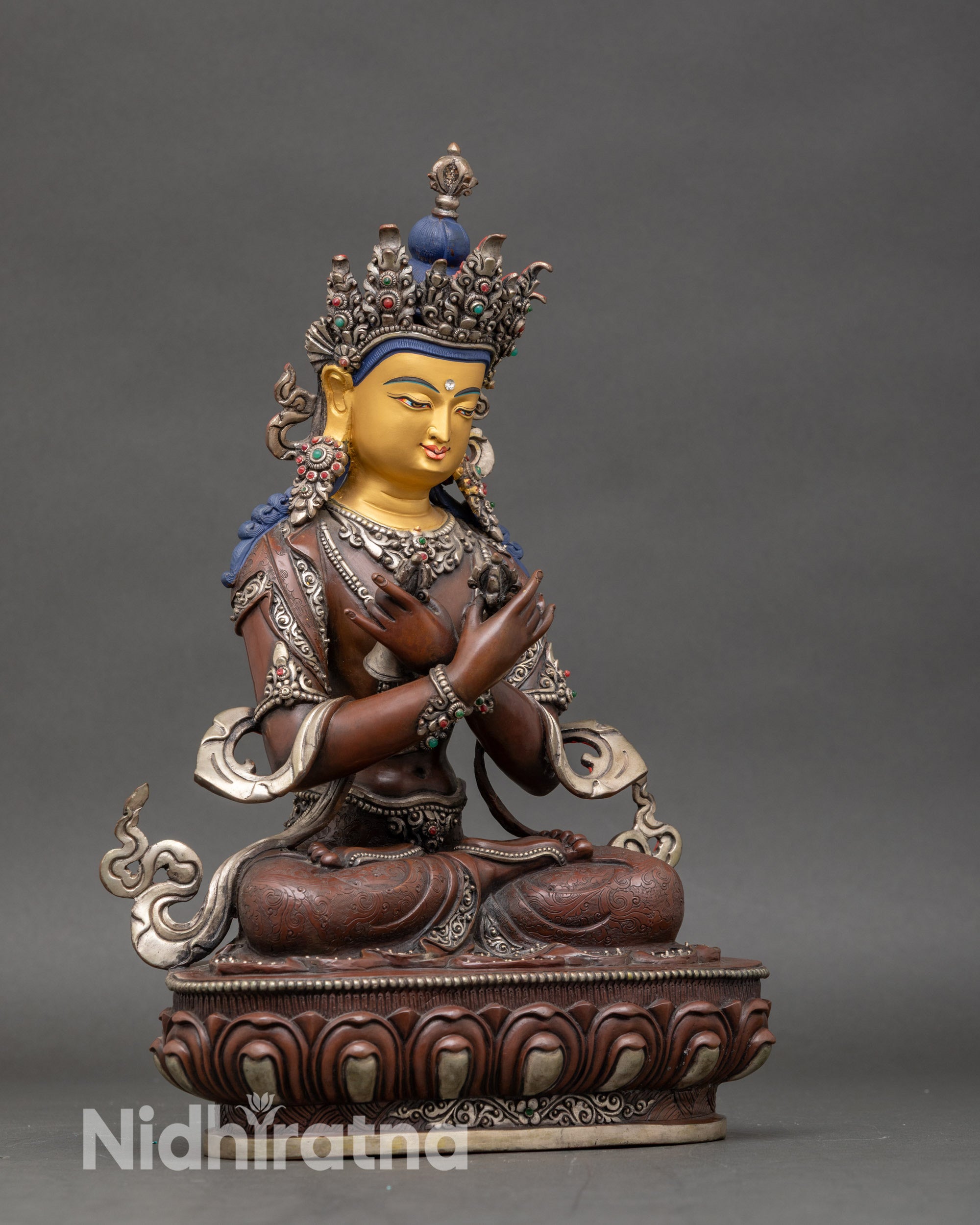 Side view of Nepalese Vajradhara statue with oxidized silver finish and gold-painted face