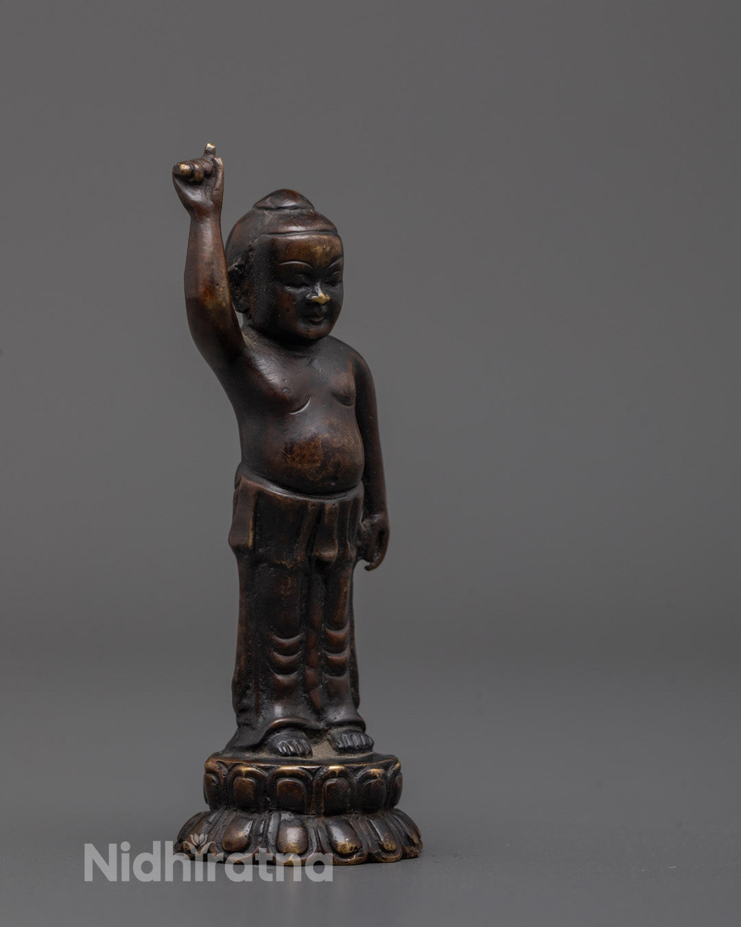 Side angle of Baby Buddha statue showing intricate carvings and lotus base