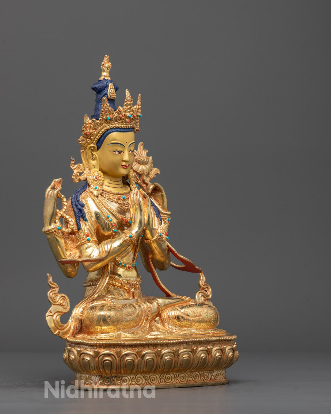 Side angle of Chenrezig statue with intricately carved ornaments and multiple arms