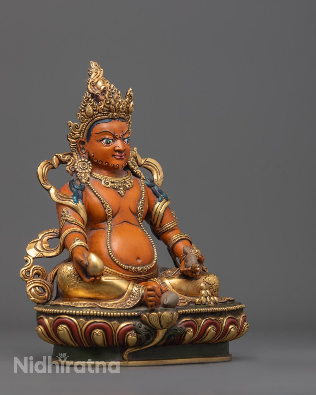 Side angle of Dzambhala Sculpture seated on lotus throne holding citron fruit and mongoose