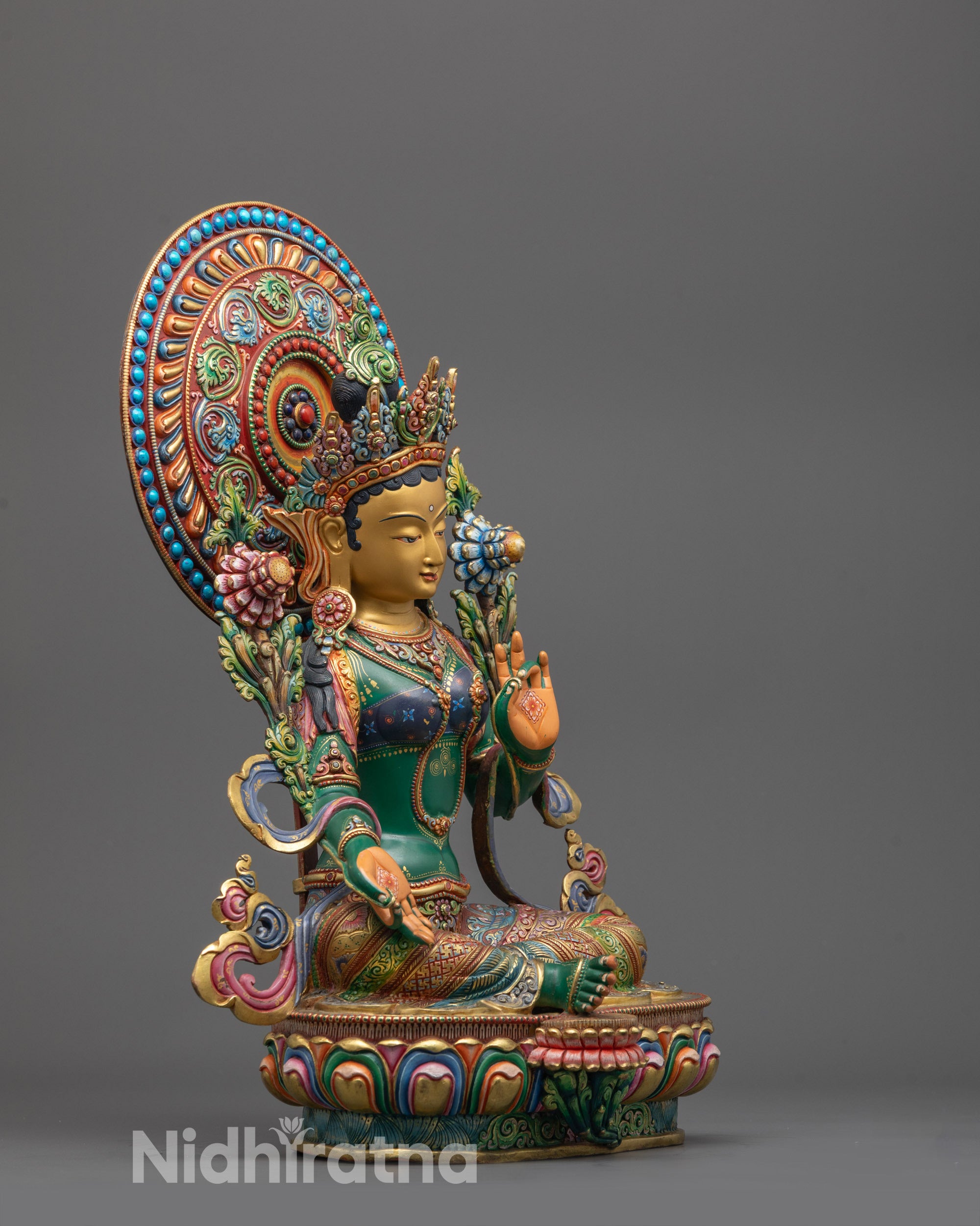 Side angle of Green Tara sculpture showing intricate halo and peaceful expression
