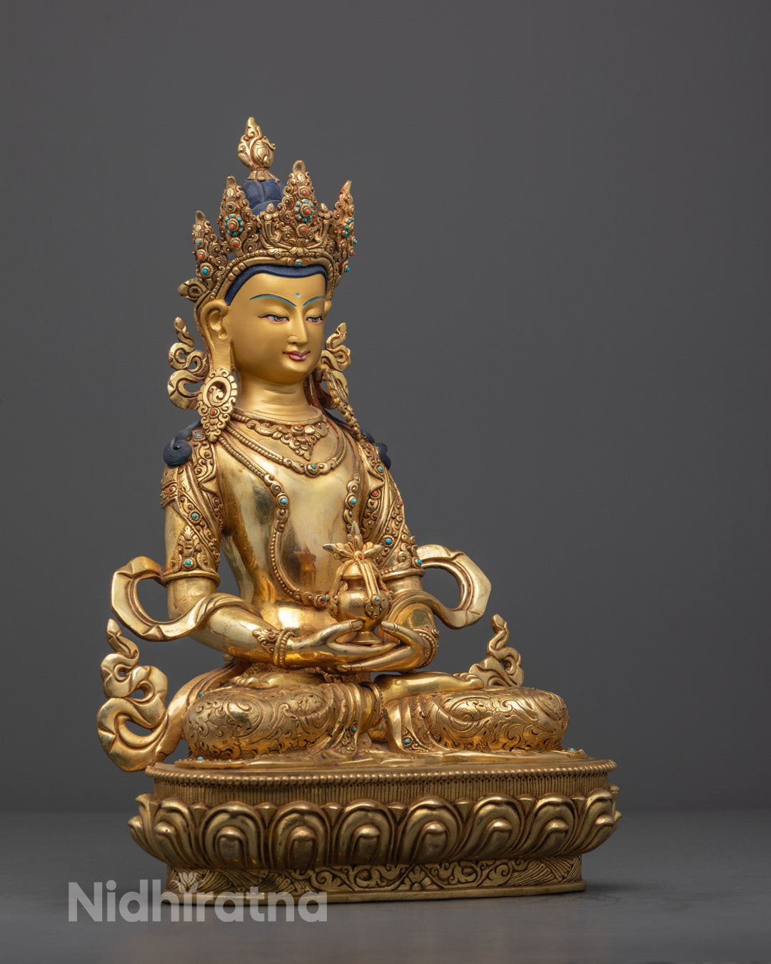 Side angle of Nepali-made Amitayus sculpture displaying the sacred vase of longevity and detailed ornaments