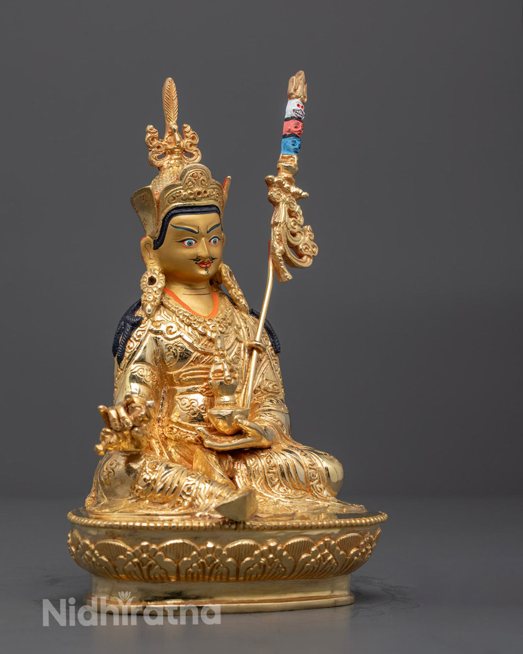 Side angle of Padmasambhava statue seated on lotus throne with sacred ornaments