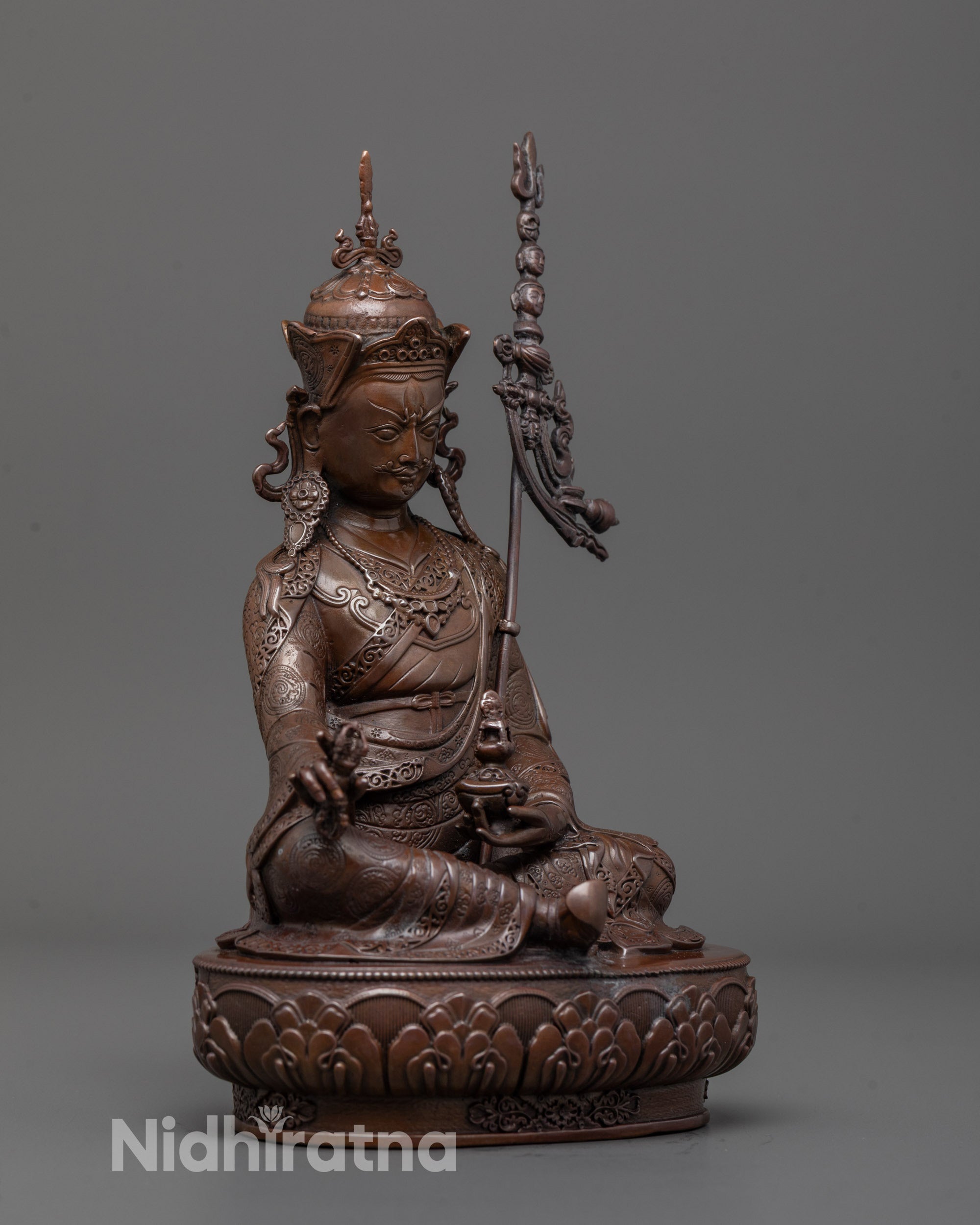 Side angle of Padmasambhava statue showing detailed robe patterns and semi-wrathful
