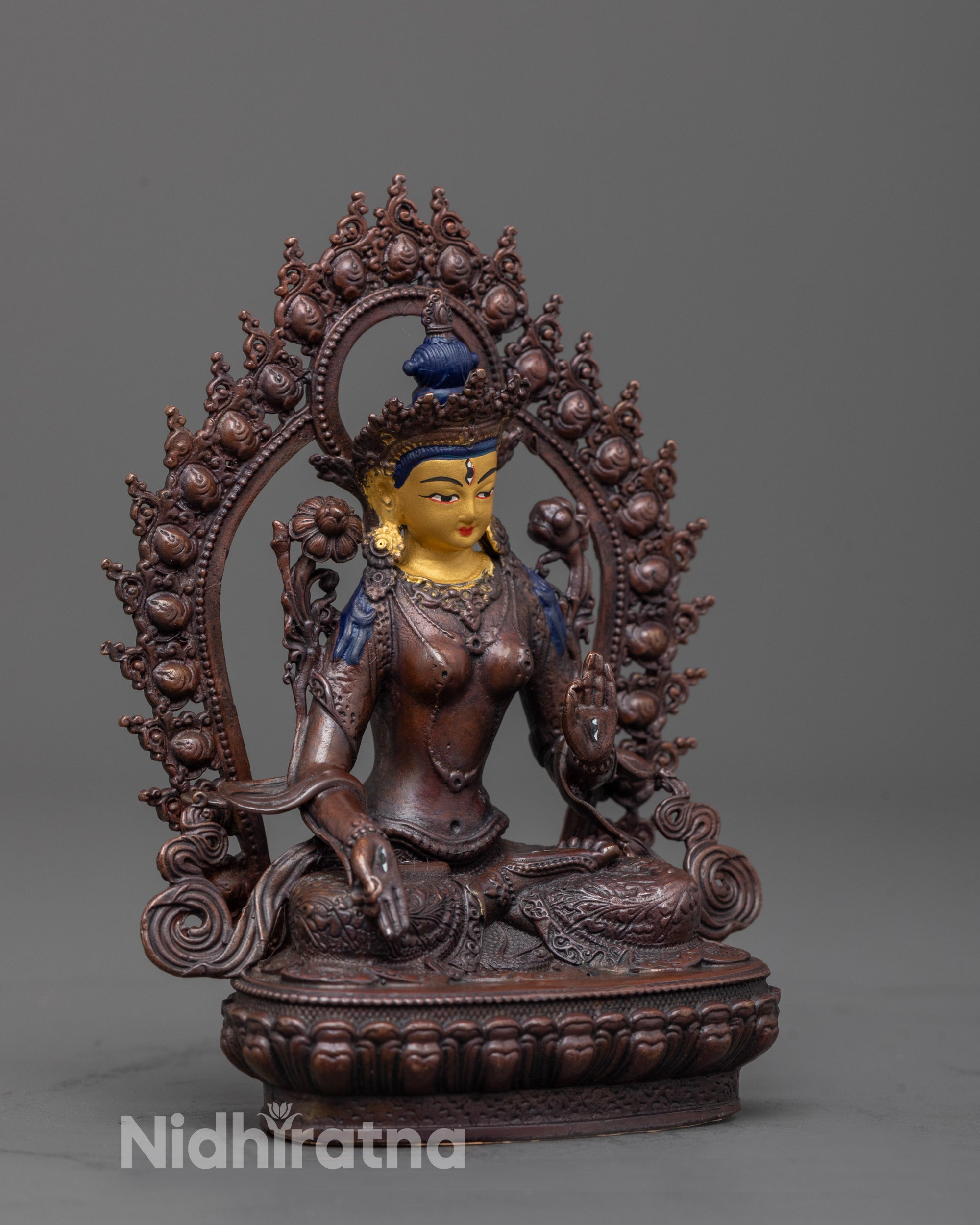 Side angle of White Tara Statue seated on lotus seat with glowing halo and earthy tones