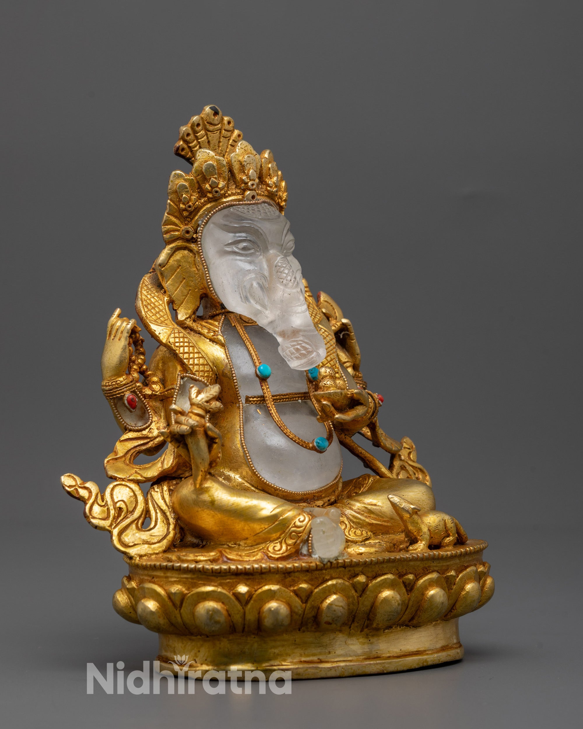 Side angle of divine Ganesh statue holding modak, mala, axe, and broken tusk