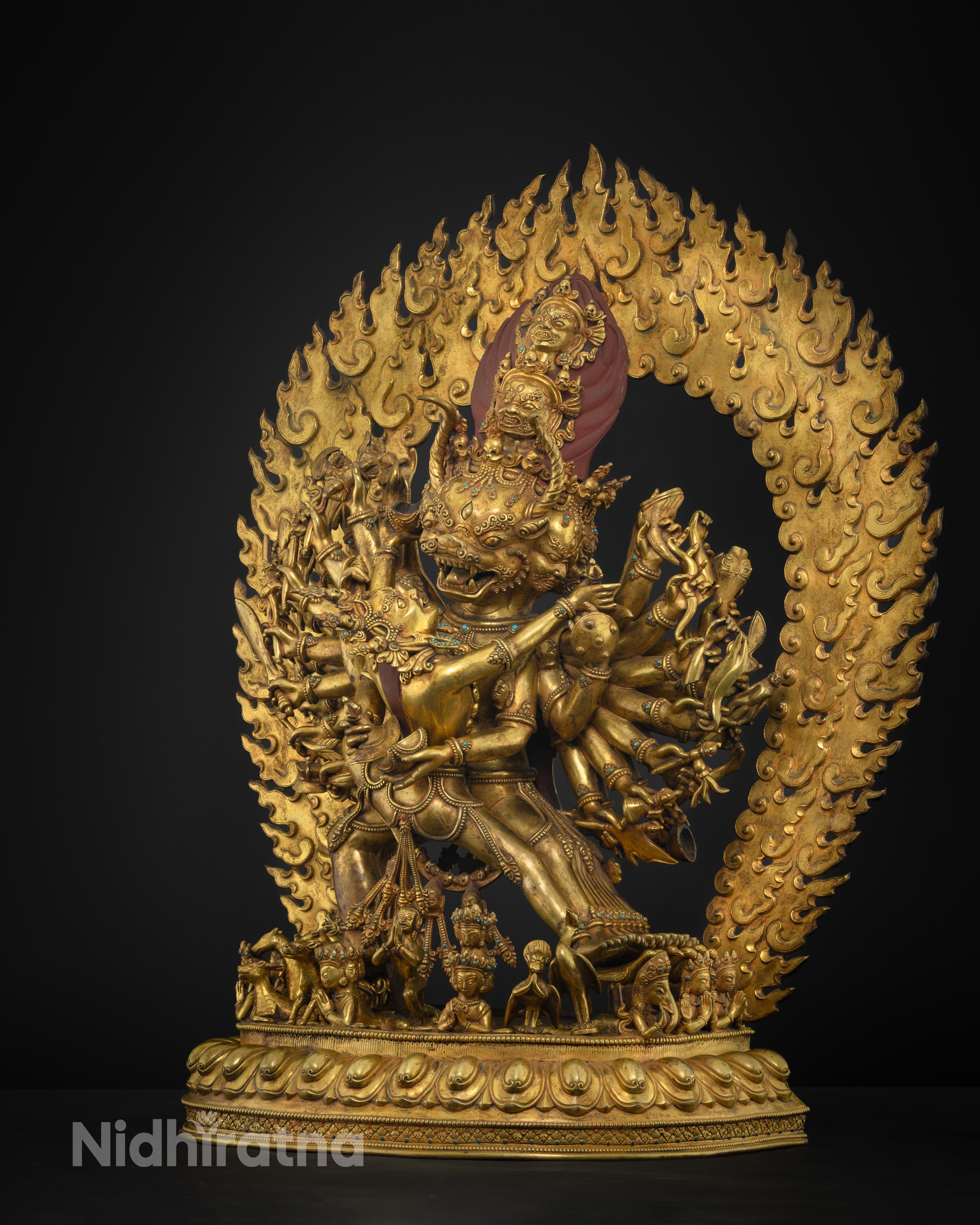 Side angle of gold-gilded Yamantaka holding kartika knife and kapala, lotus base visible