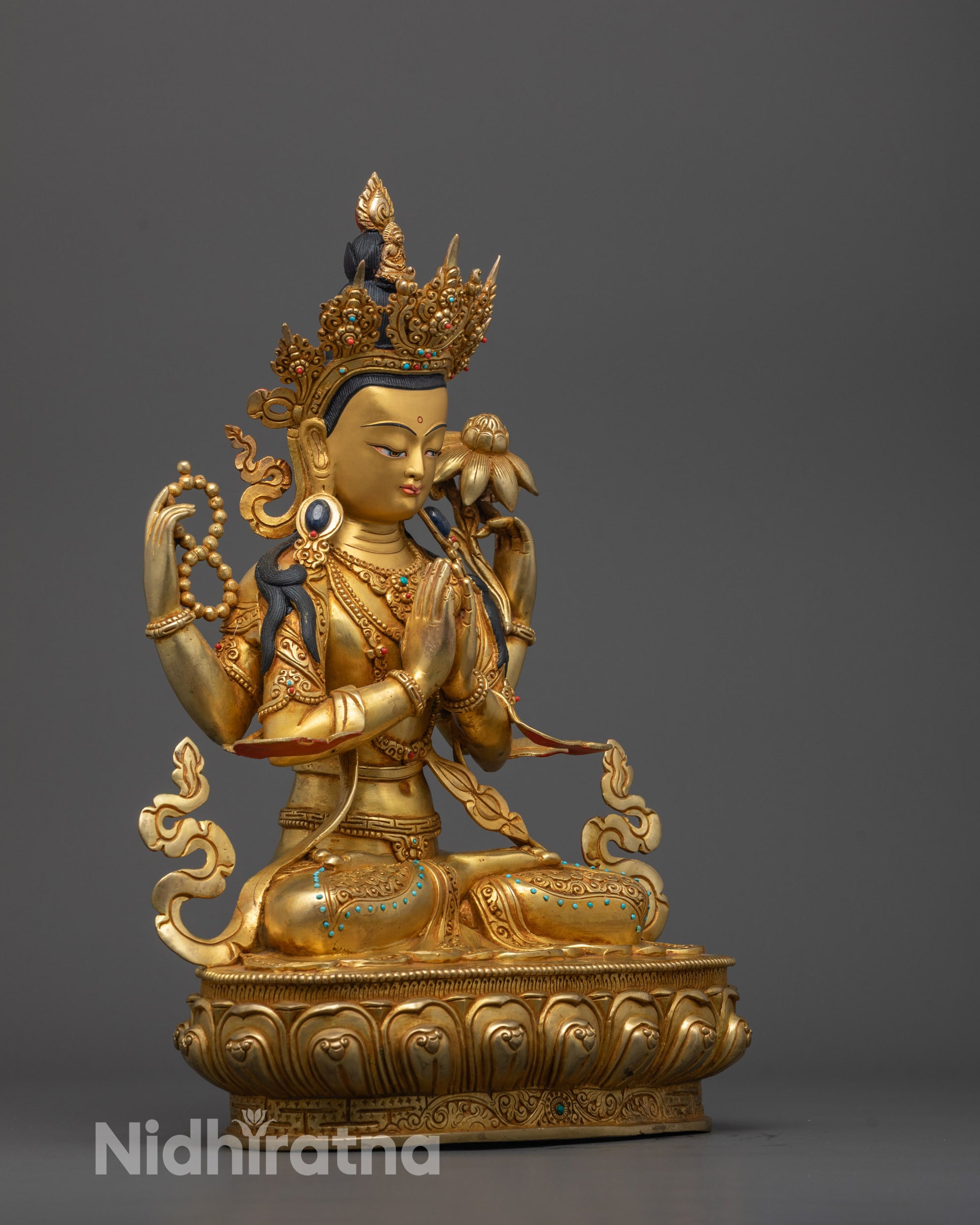 Side angle of hand-carved Chenrezig Statue showing four arms with symbolic attributes
