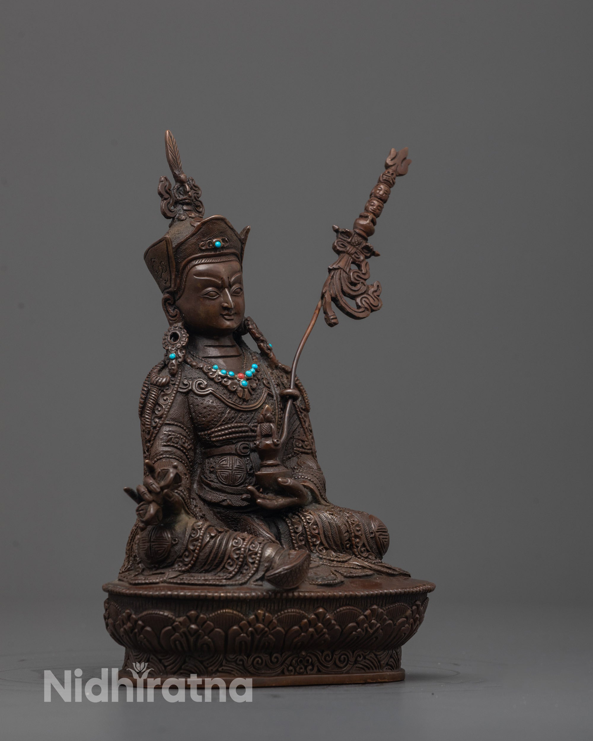 Side angle of handcrafted Padmasambhava Sculpture seated on lotus throne with trident and ornaments