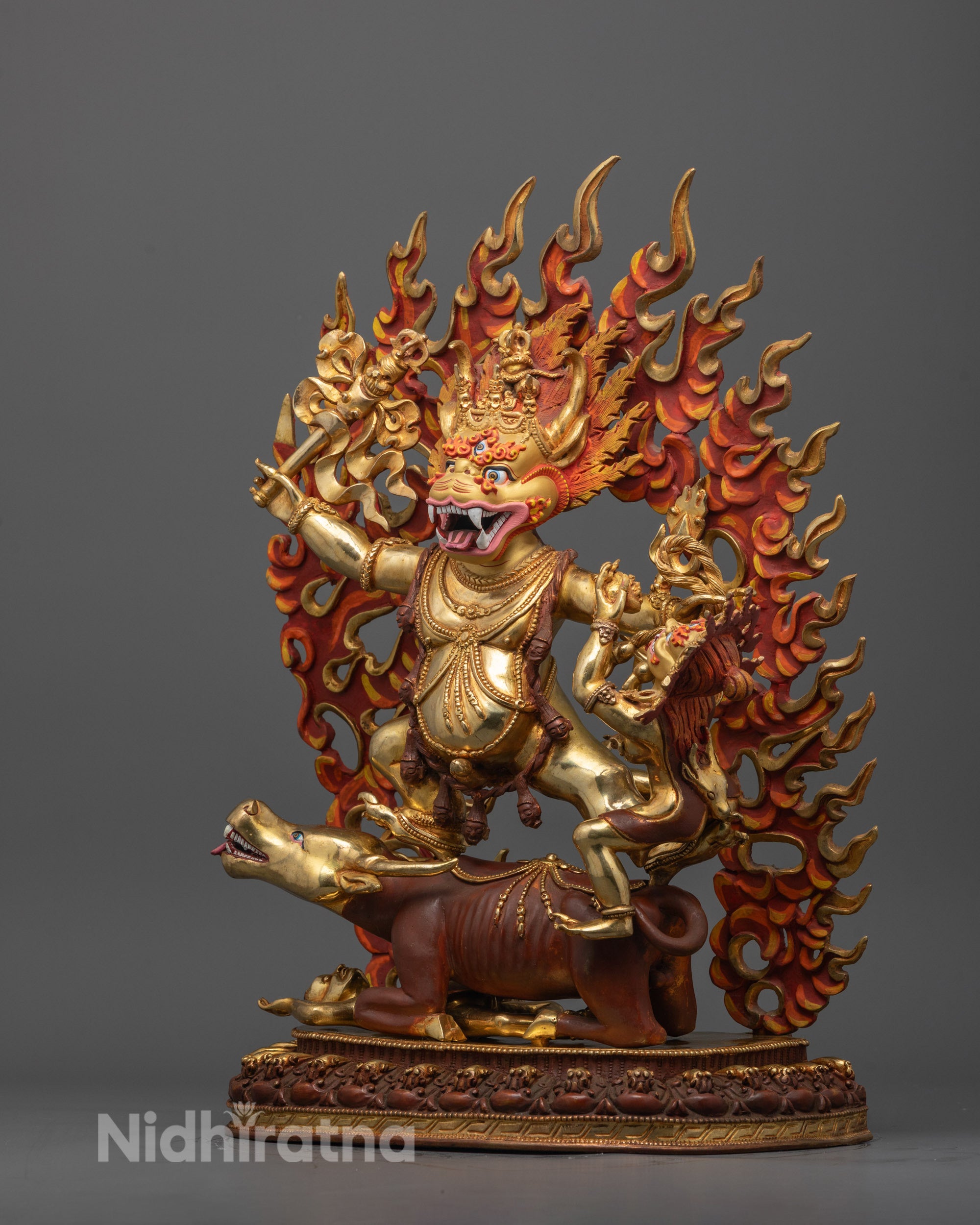 Side angle of handcrafted Yamantaka statue showing gold-gilded body and buffalo with halo