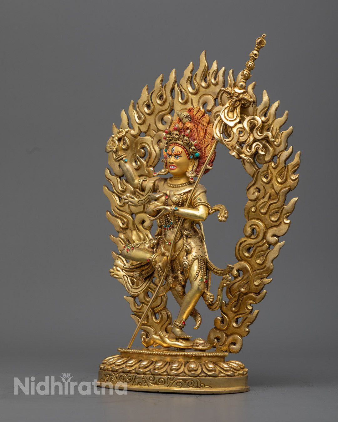Side angle of handcrafted gold-gilded Troma Nagmo statue in dynamic dancing posture