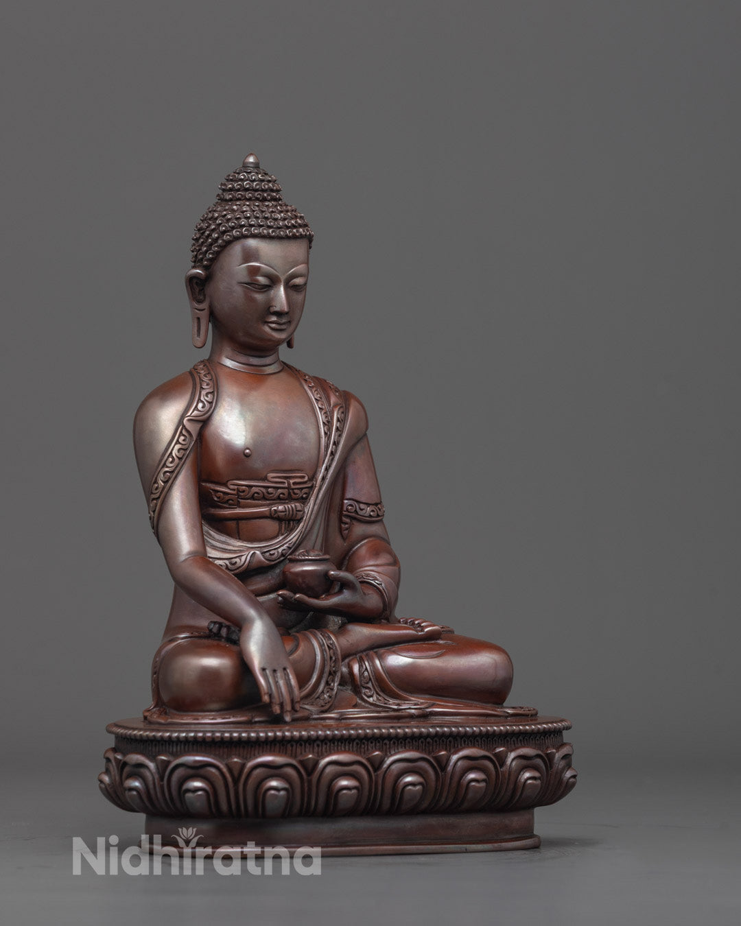 Side angle of oxidized Gautama Buddha on lotus throne showing detailed carving.