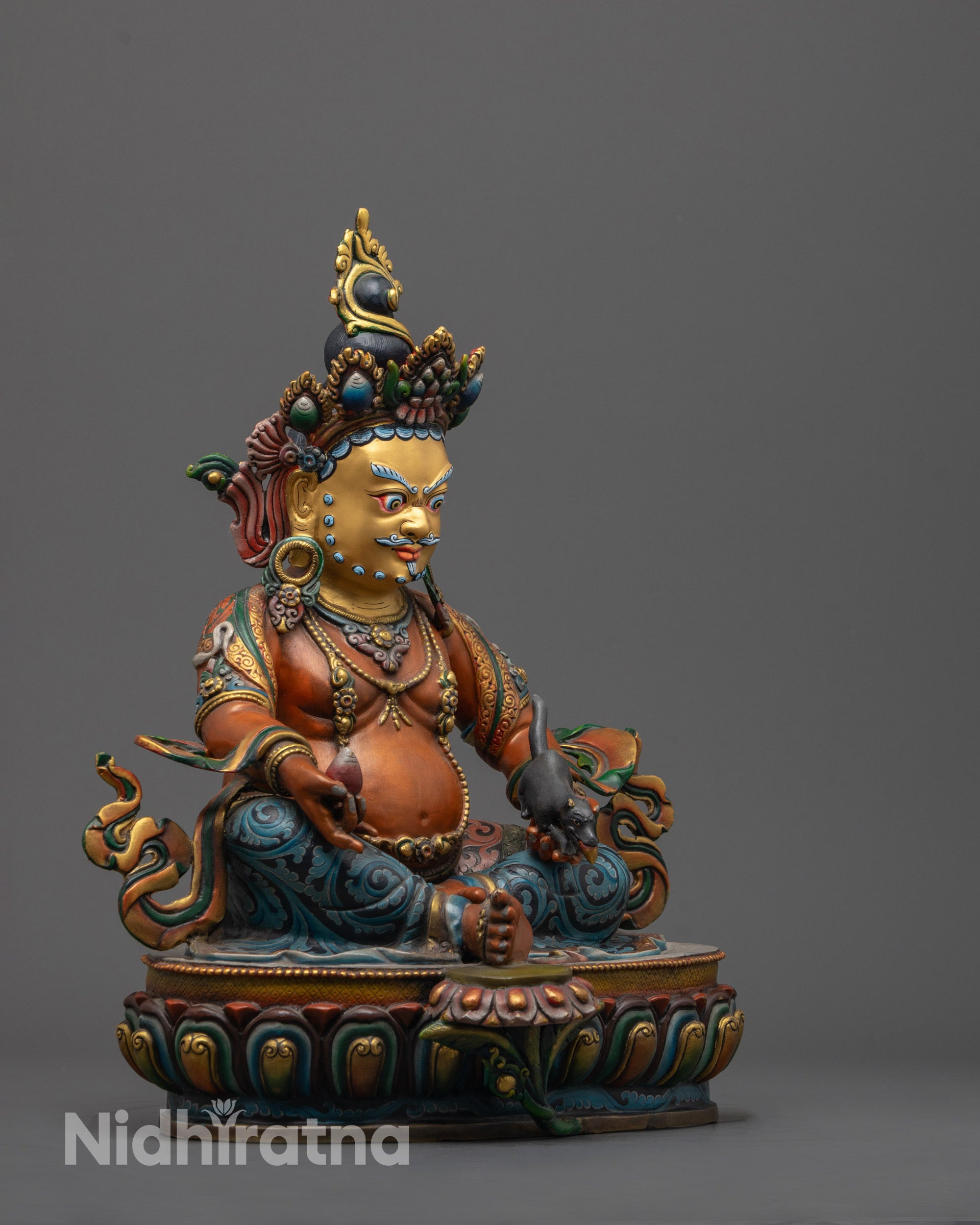 Side angle showing Dzambhala’s beautifully painted orange body, symbolic lotus seat