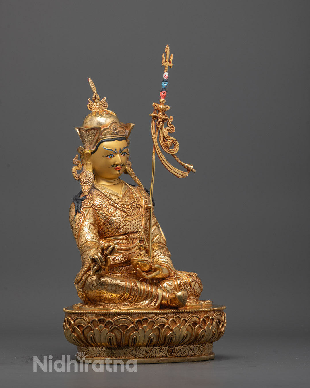 Side angle showing Vajra, skull vase, and Khatvang trident held by the statue